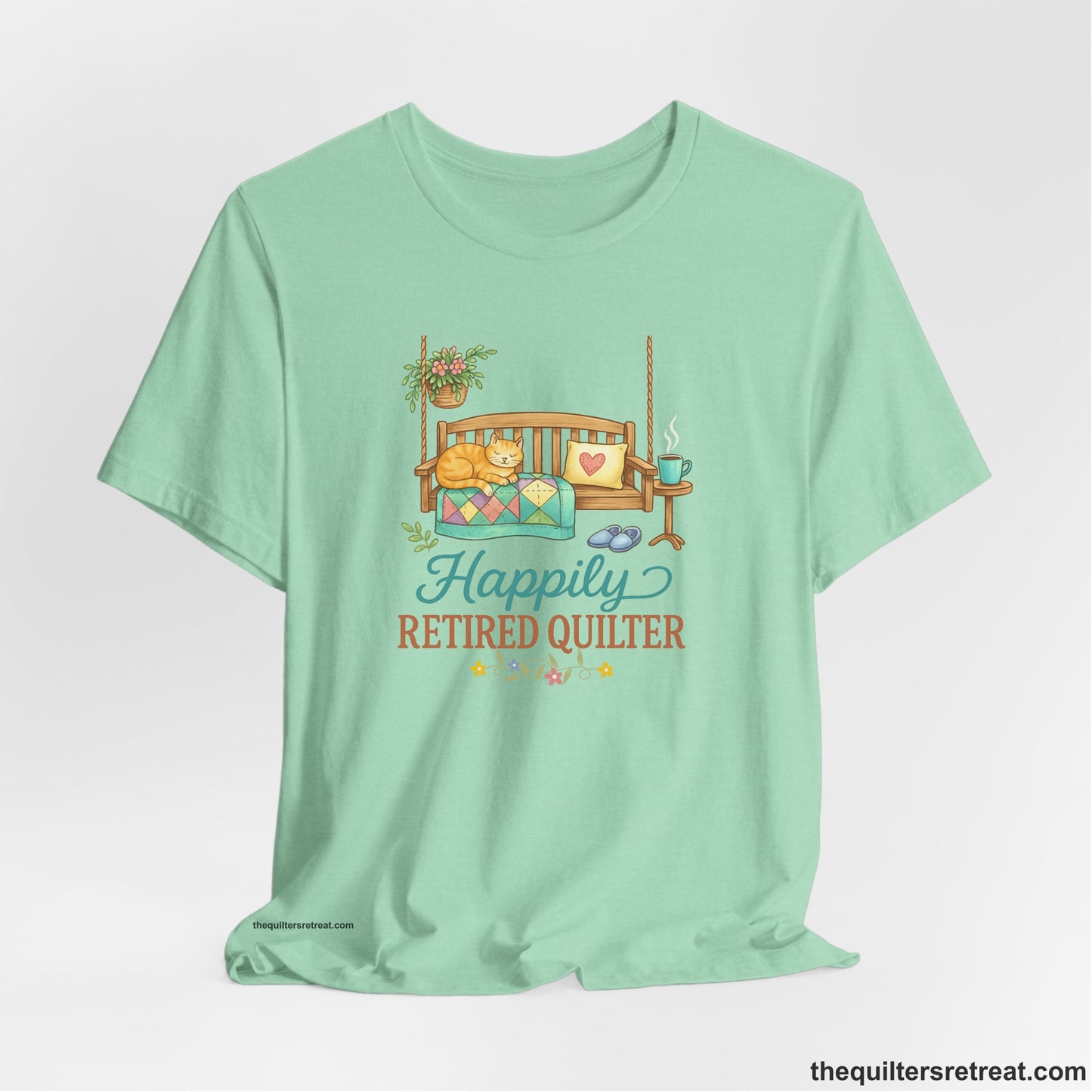 A Short Sleeve T-Shirt with a hanging bench with cozy cat and quilt, surrounded by plants, "Happily Retired Quilter" text