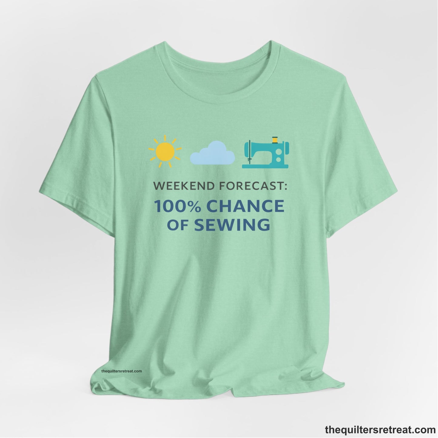 A Heather Mint Short Sleeve T-Shirt with a Sun, cloud, sewing machine icons; bold text "Weekend Forecast: 100% Chance of Sewing"; playful style.