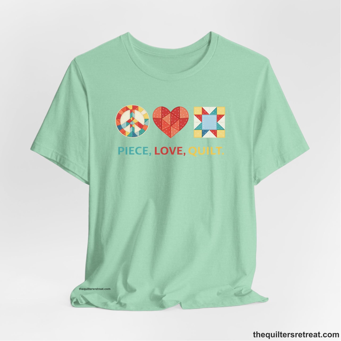 A Heather Mint Short Sleeve T-Shirt with a Colorful quilt patterns, "PIECE, LOVE, QUILT." text, whimsical style.