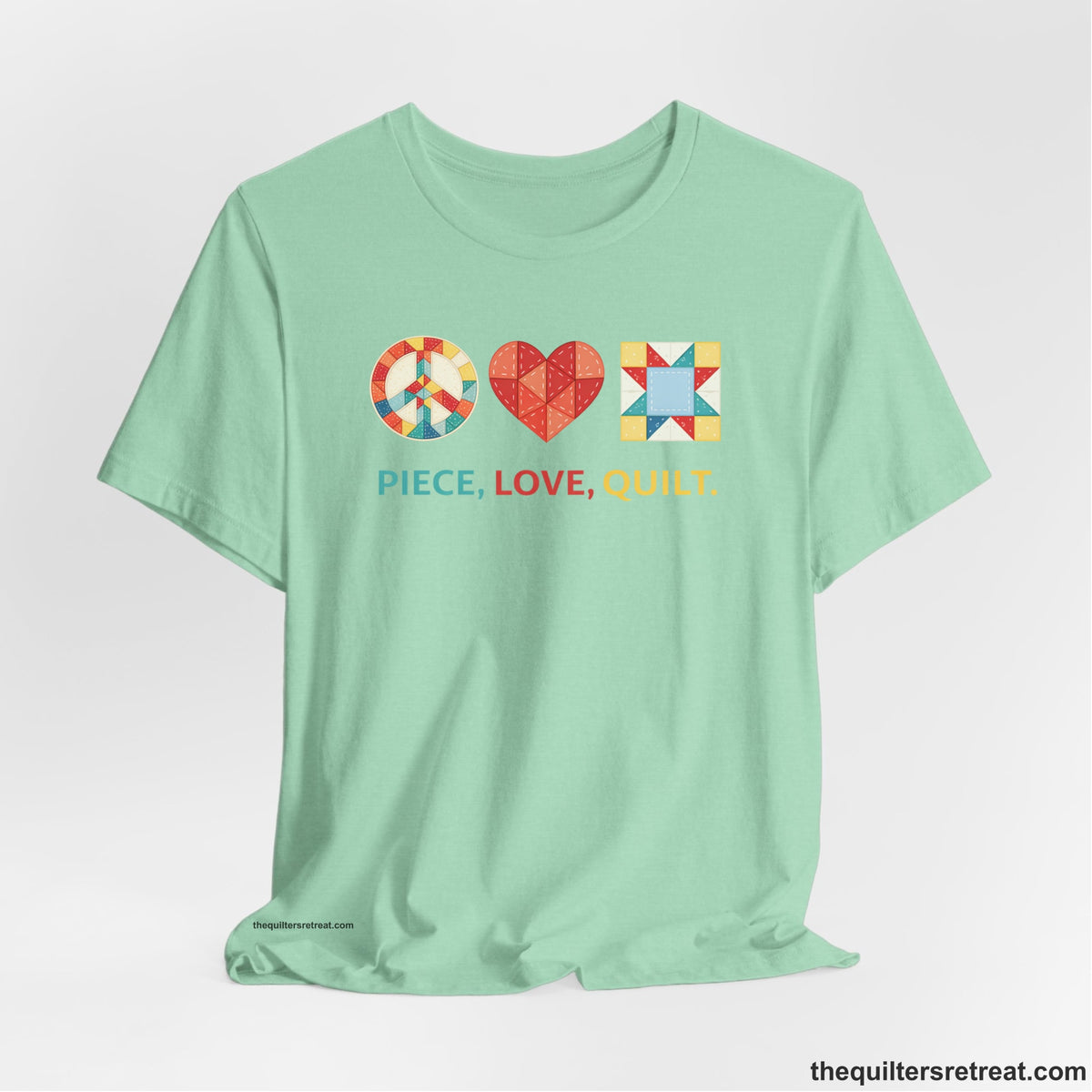 A Heather Mint Short Sleeve T-Shirt with a Colorful quilt patterns, "PIECE, LOVE, QUILT." text, whimsical style.