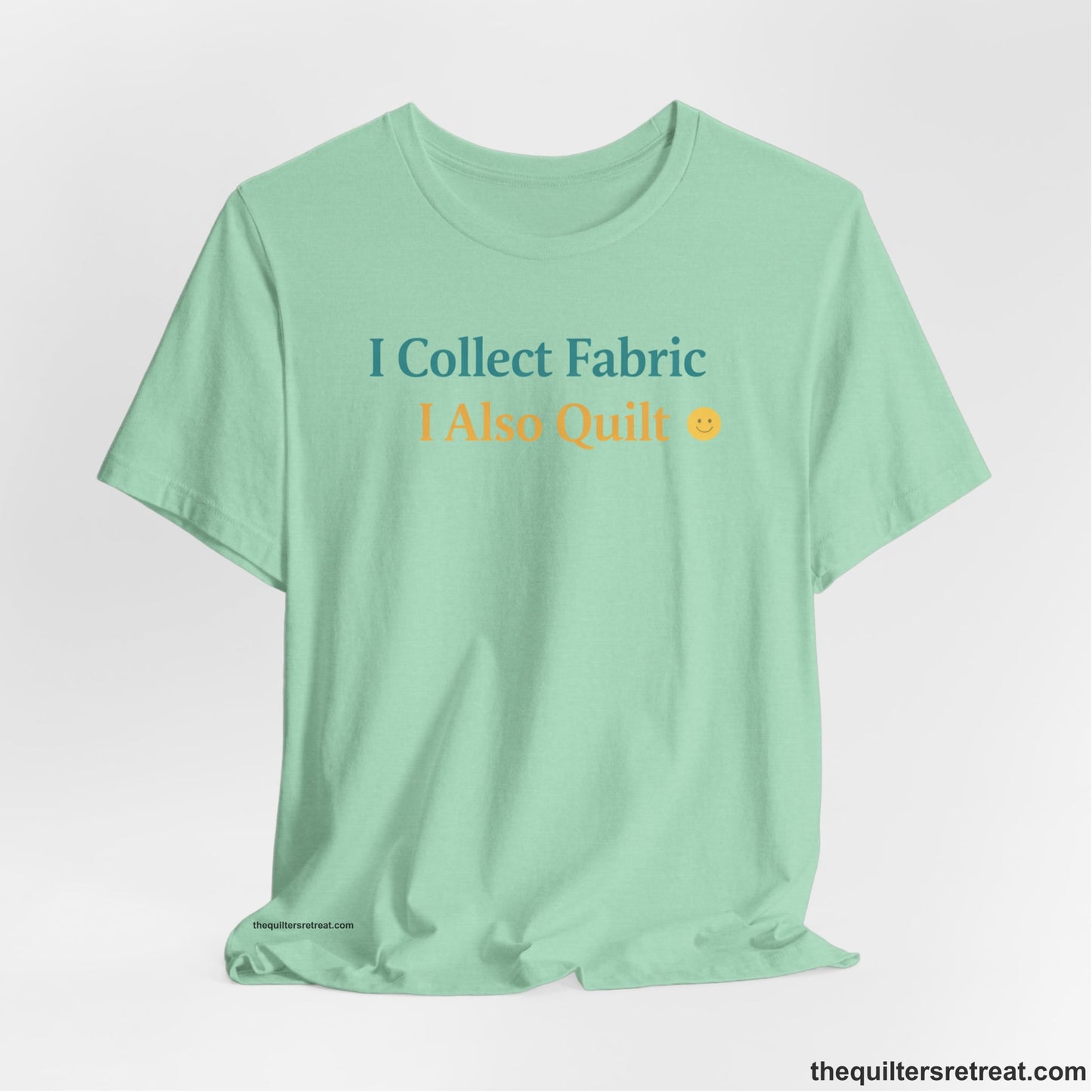 A Heather Mint Short Sleeve T-Shirt with a Colorful text saying "I Collect Fabric I Also Quilt" with a playful, cheerful vibe.