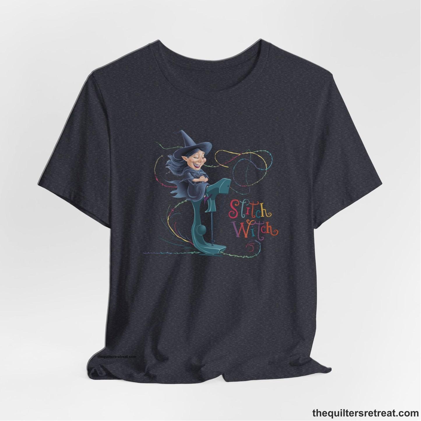 A Heather Navy Short Sleeve T-Shirt with a witch on vintage sewing machine with "Stitch Witch" text in playful, colorful style