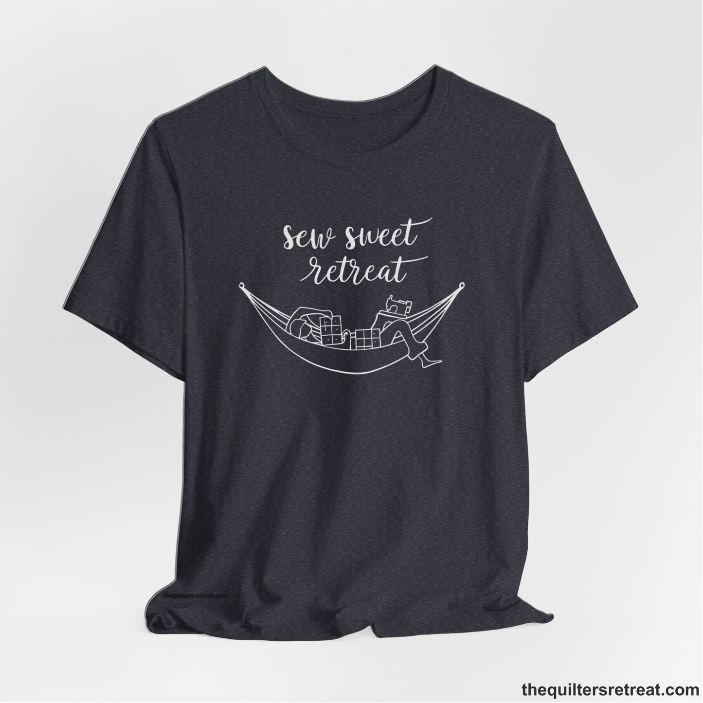 A Heather Navy Short Sleeve T-Shirt with a sewing machine and thread spools with "Sew Sweet Retreat" in whimsical script