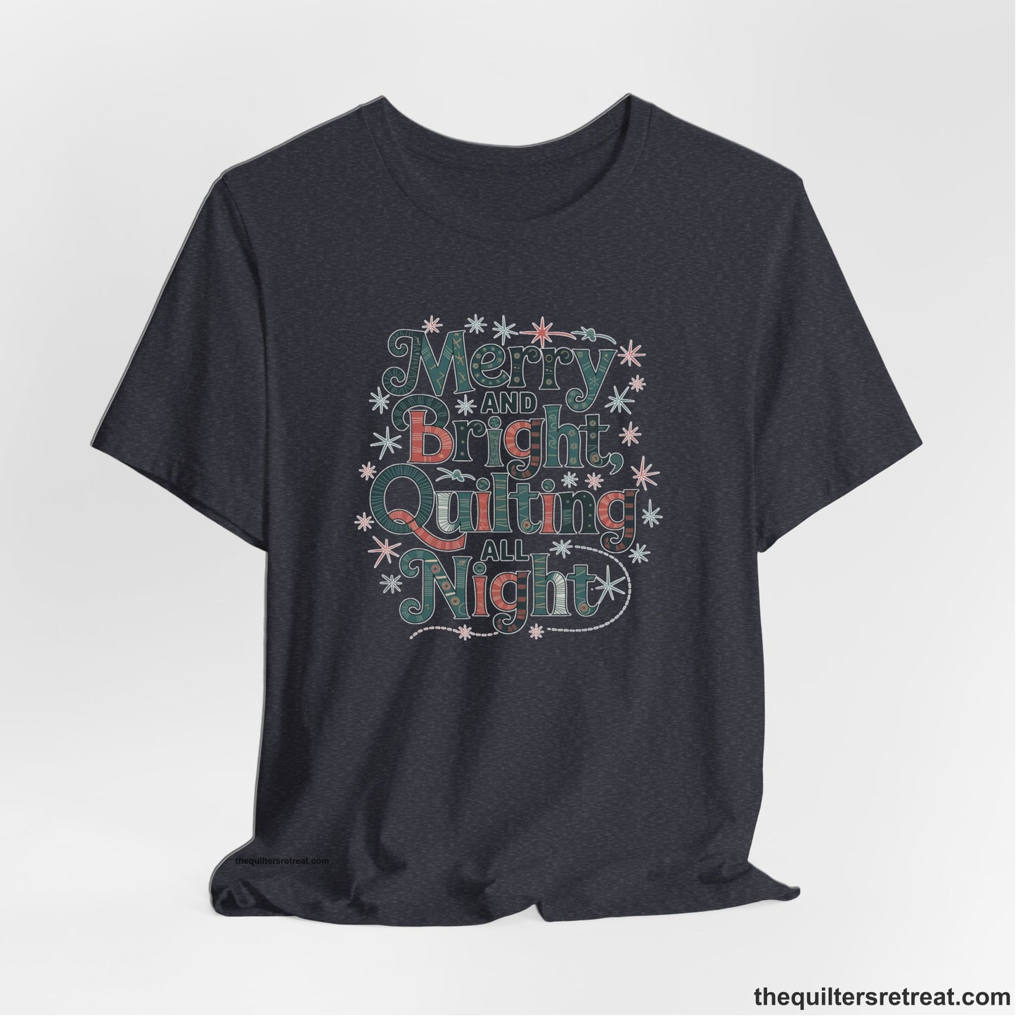 A Heather Navy Short Sleeve T-Shirt with a Merry and Bright Quilting All Night text with festive patterns and stars in a whimsical style