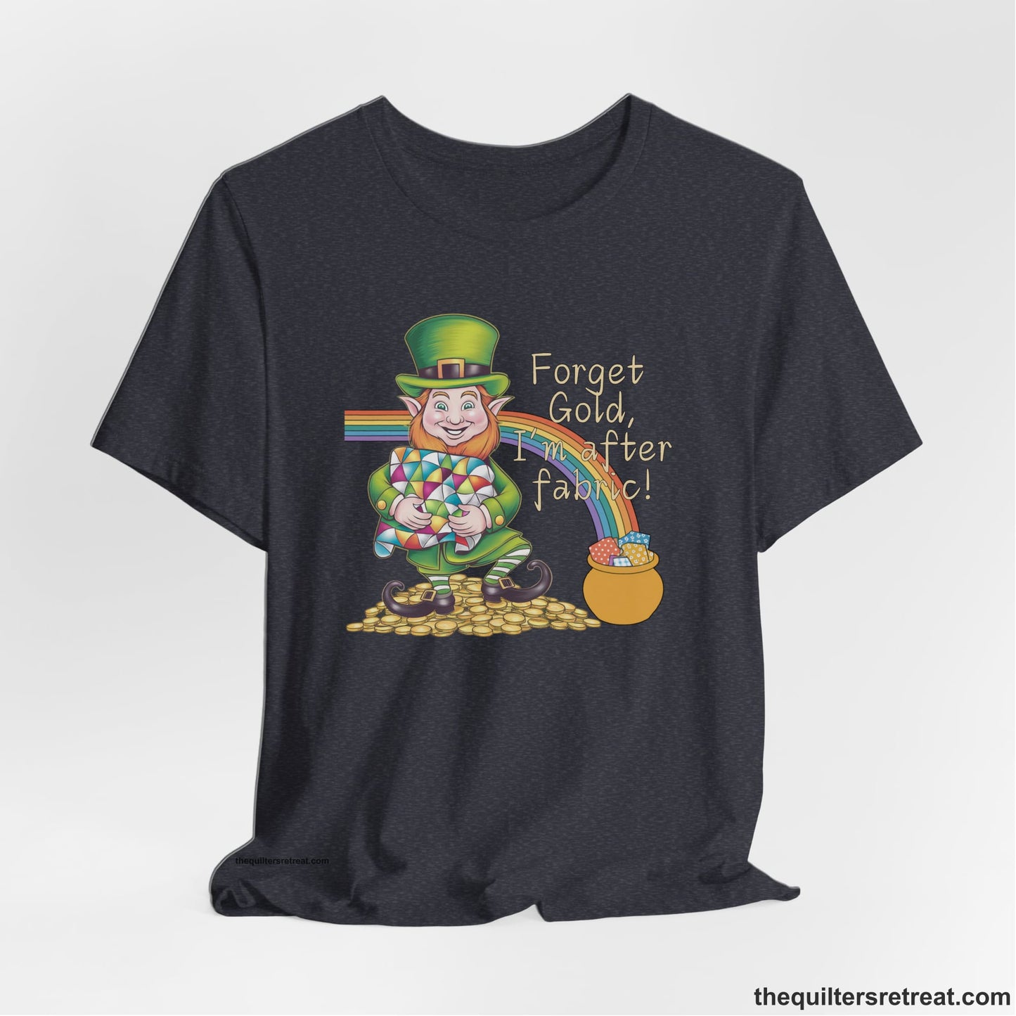A Heather Navy Short Sleeve T-Shirt with a leprechaun with colorful quilt and rainbow, whimsical "Forget Gold, I'm after fabric!" text