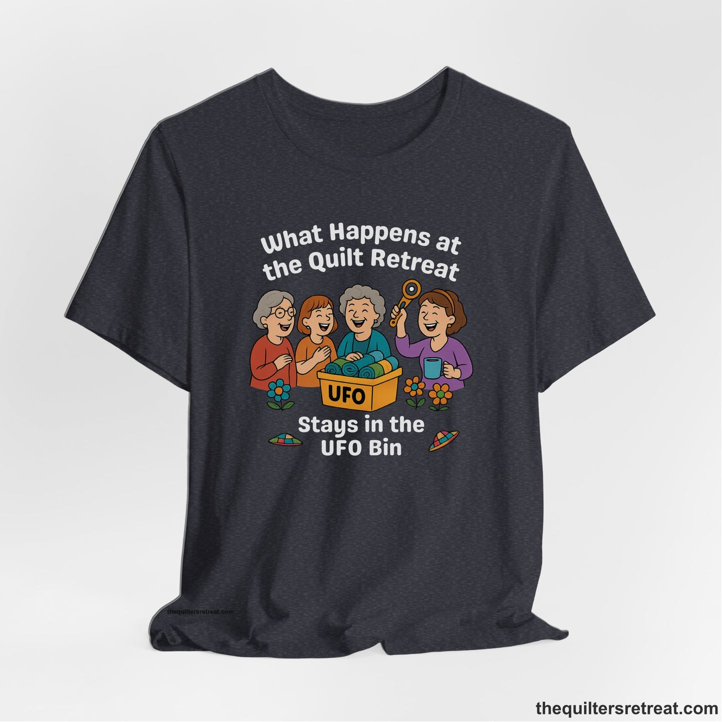 A Heather Navy Short Sleeve T-Shirt with a four smiling women with unfinished fabric objects and playful "UFO" text in a cartoon style
