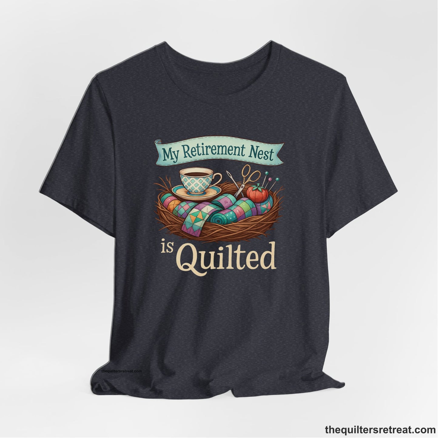A Heather Navy Short Sleeve T-Shirt with a My Retirement Nest is Quilted text with a cozy sewing elements illustration