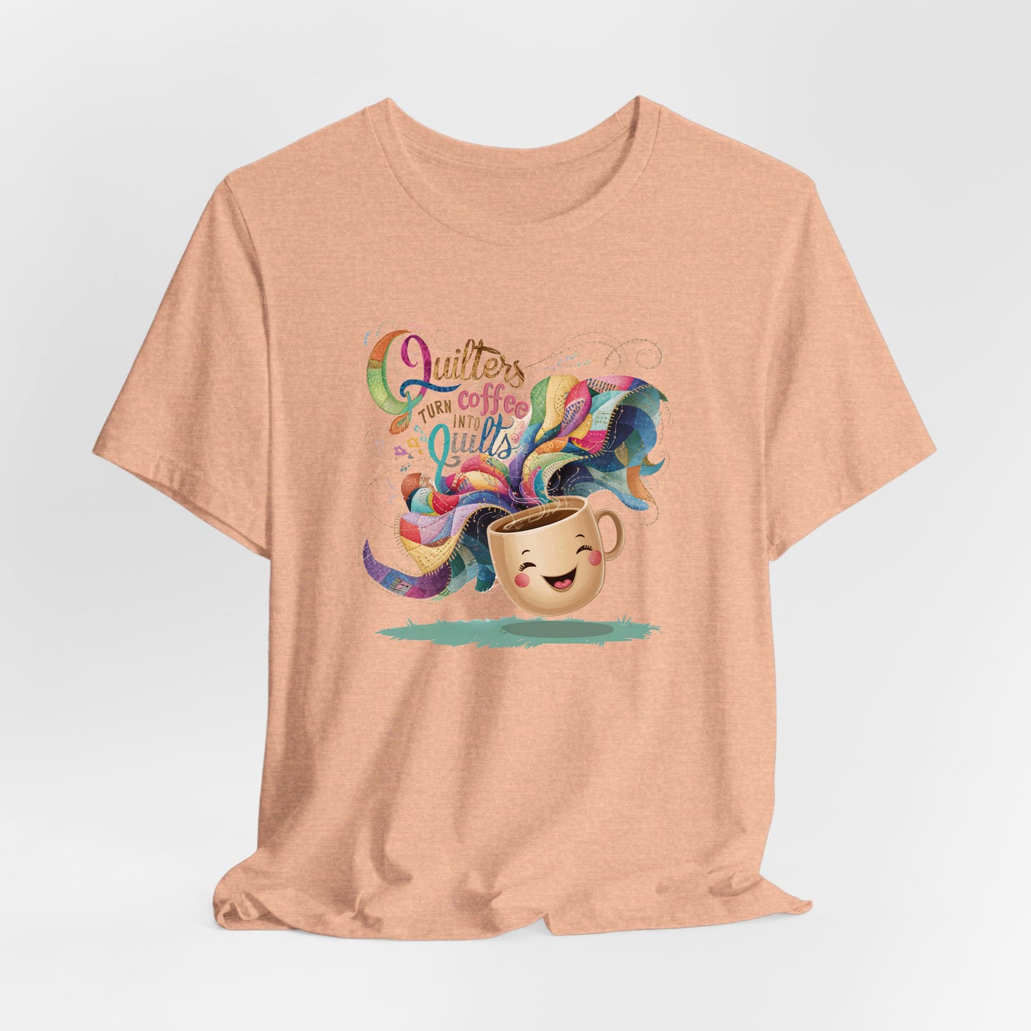 A Heather Peach Short Sleeve T-Shirt with a quirky "Quilters Turn Coffee into Quilts" text with vibrant swirling patterns