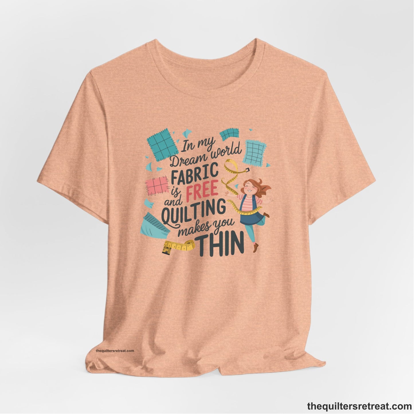 A Heather Peach Short Sleeve T-Shirt with a inspirational quilting text with playful seamstress and colorful fabric scraps in whimsical style