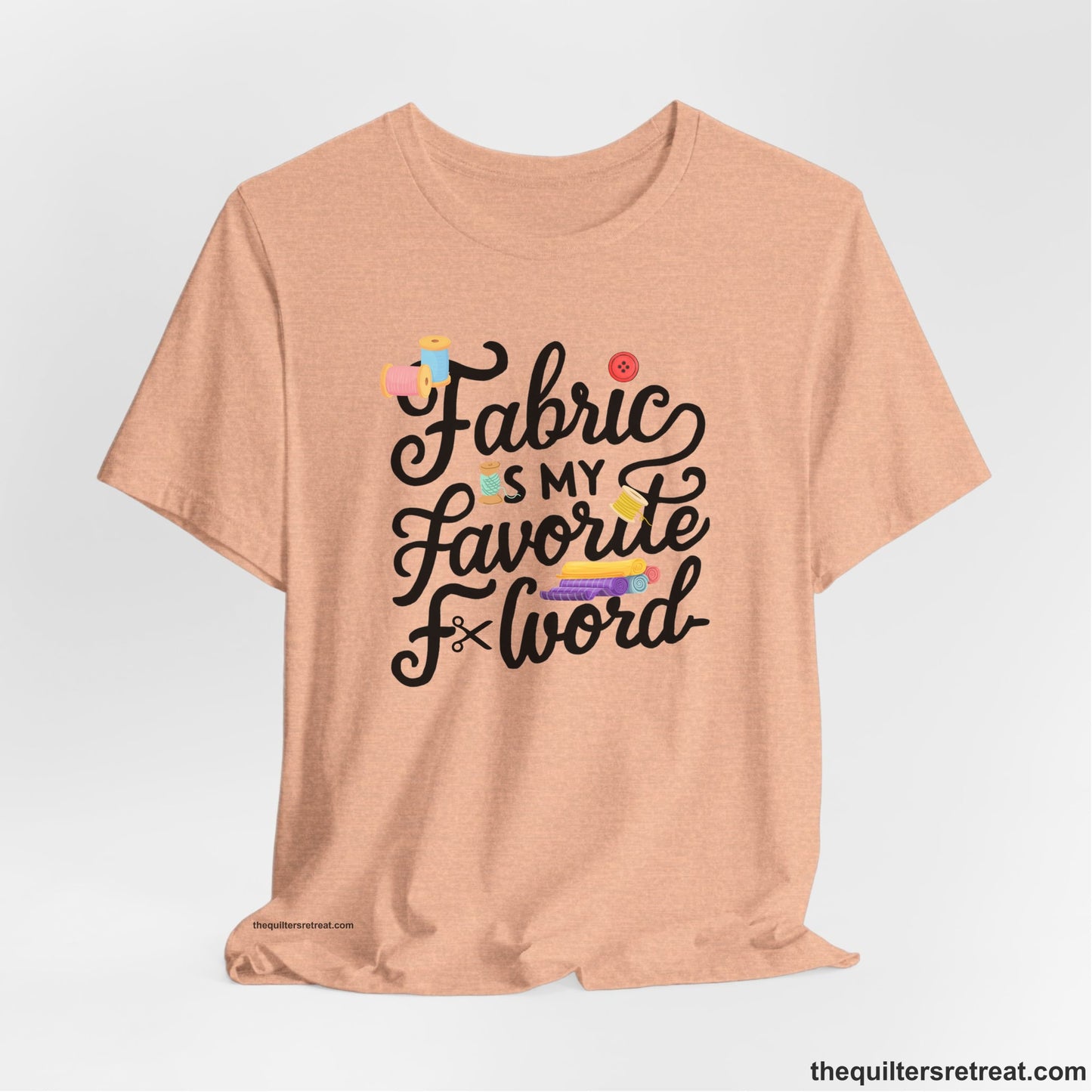 A Heather Peach Short Sleeve T-Shirt with a fabric is my favorite f word text with colorful spools and buttons in a playful style