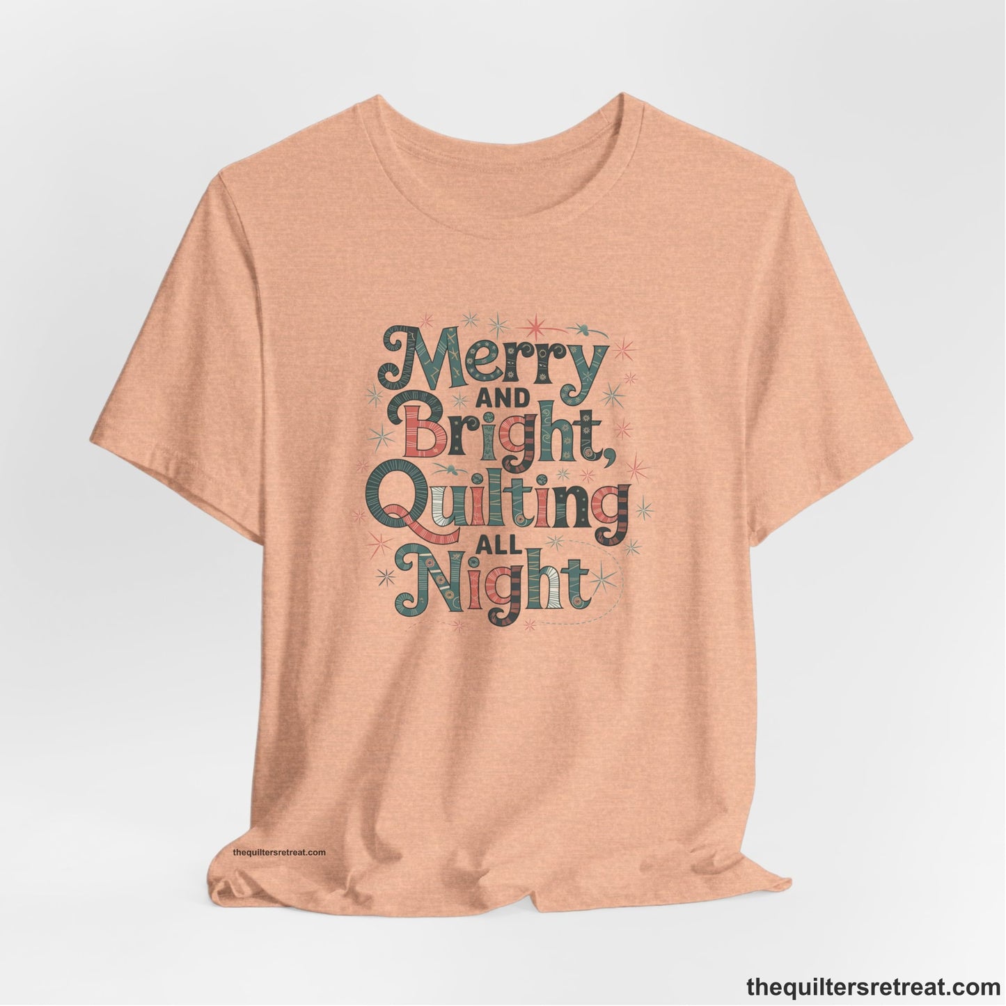 A Heather Peach Short Sleeve T-Shirt with a Merry and Bright Quilting All Night text with festive patterns and stars in a whimsical style
