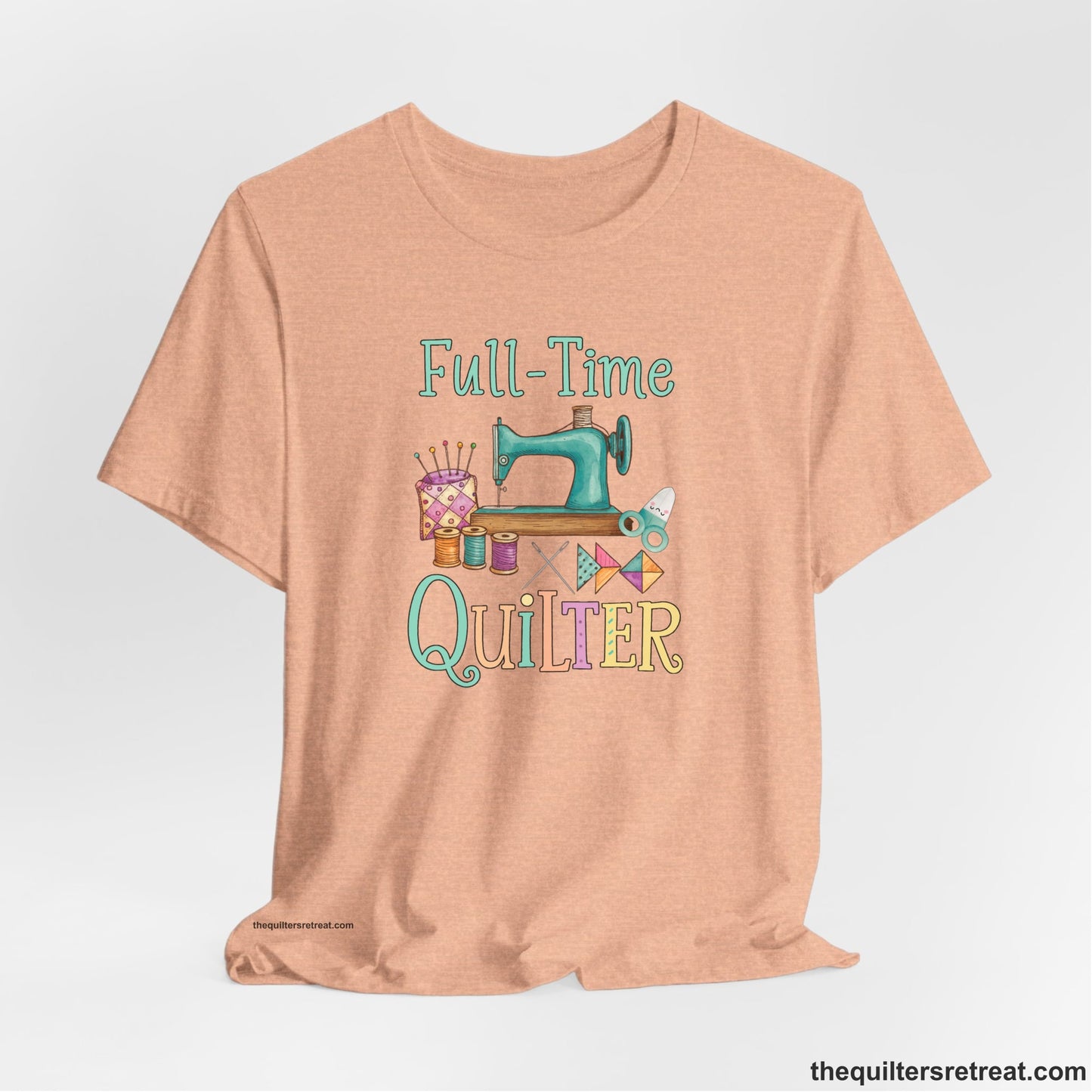 A Heather Peach Short Sleeve T-Shirt with a vintage sewing machine with colorful threads and "Full-Time Quilter" text in playful style