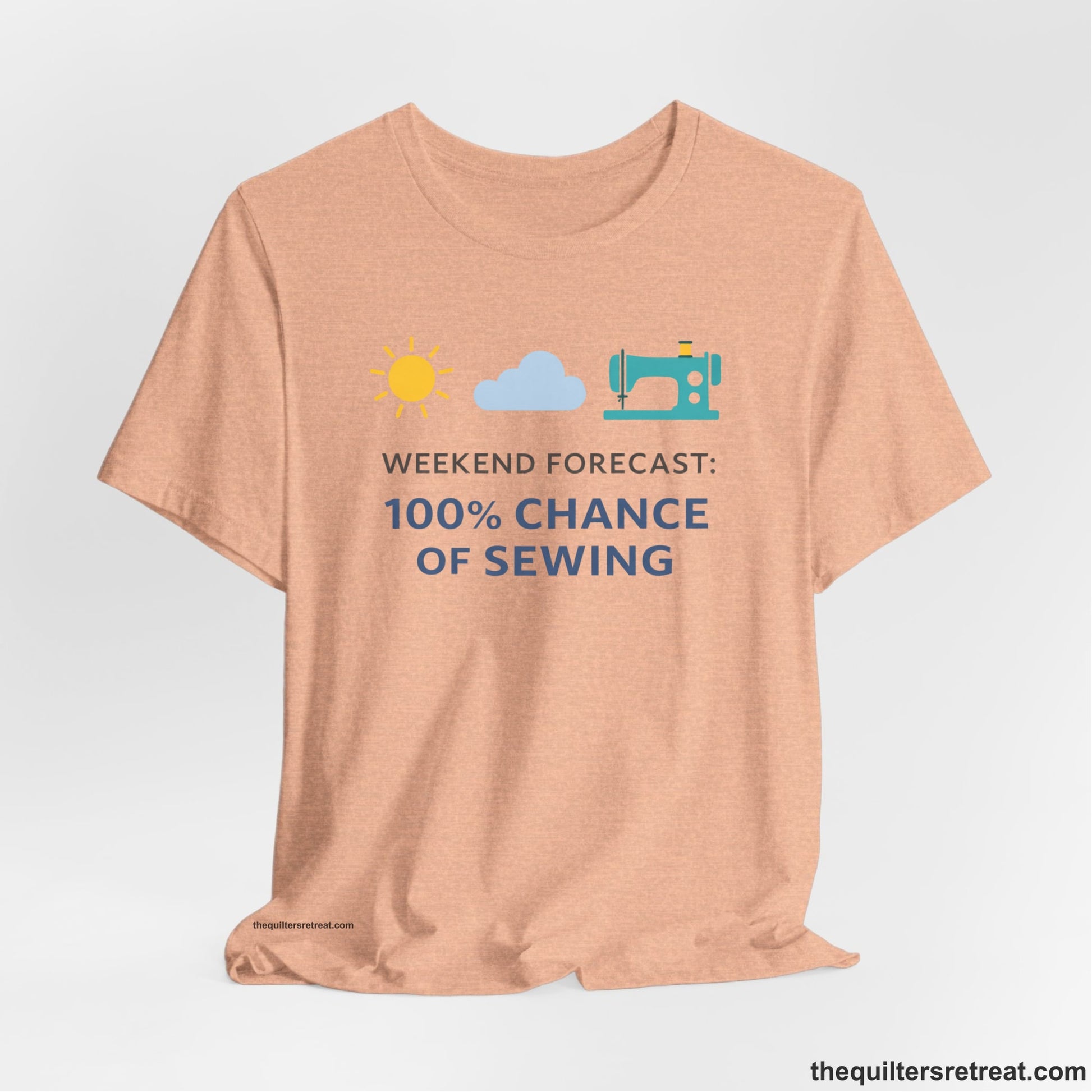 A Heather Peach Short Sleeve T-Shirt with a Sun, cloud, sewing machine icons; bold text "Weekend Forecast: 100% Chance of Sewing"; playful style.
