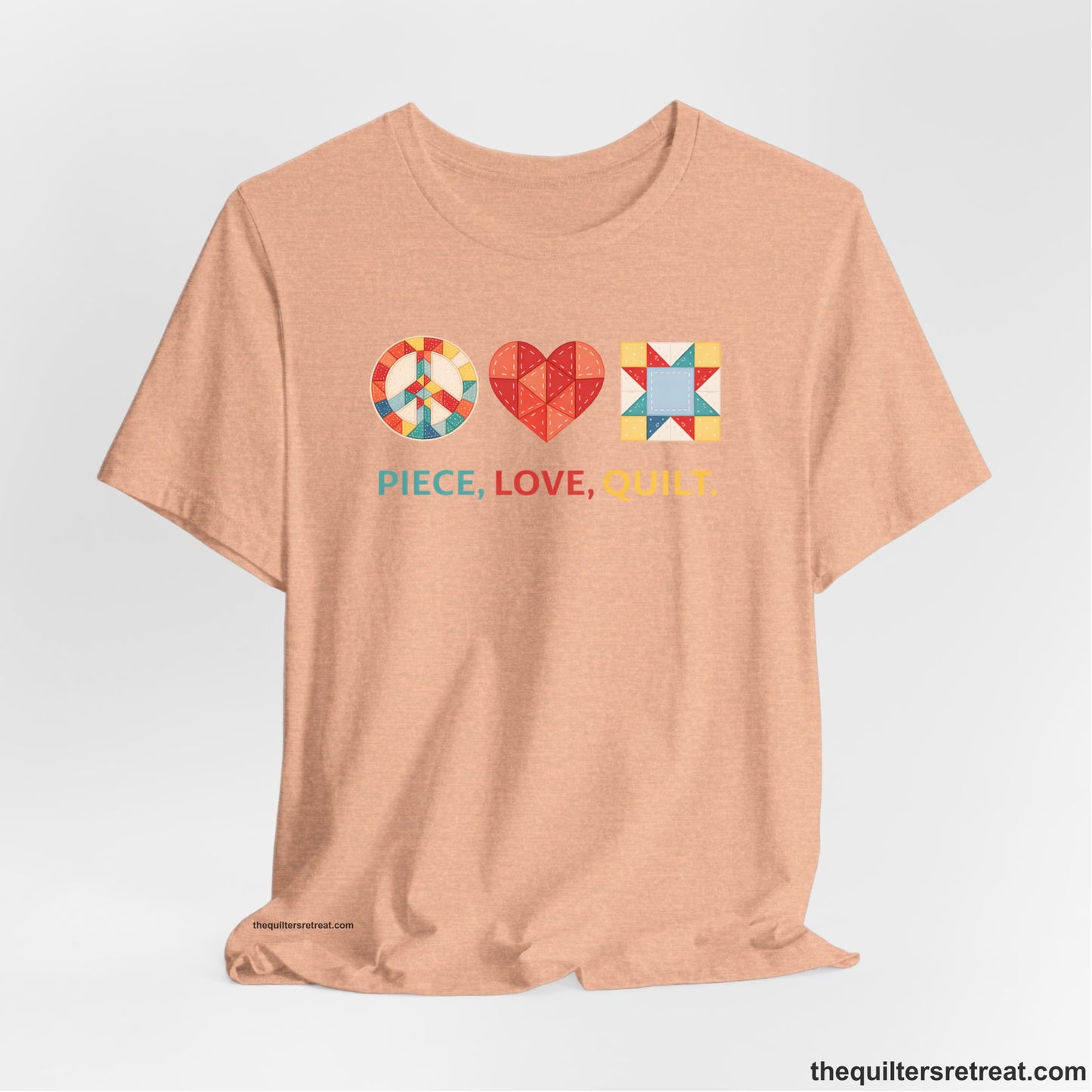 A Heather Peach Short Sleeve T-Shirt with a Colorful quilt patterns, "PIECE, LOVE, QUILT." text, whimsical style.
