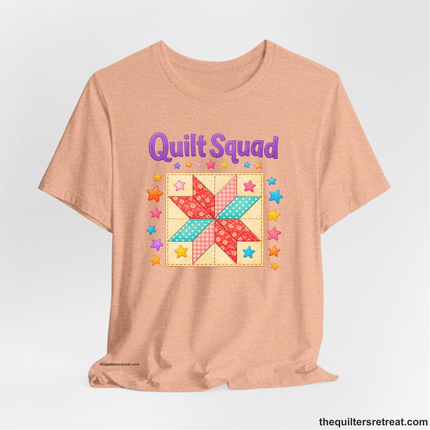 A Heather Peach Short Sleeve T-Shirt with a Patchwork quilt star with colorful stars, playful mood, "Quilt Squad" text.
