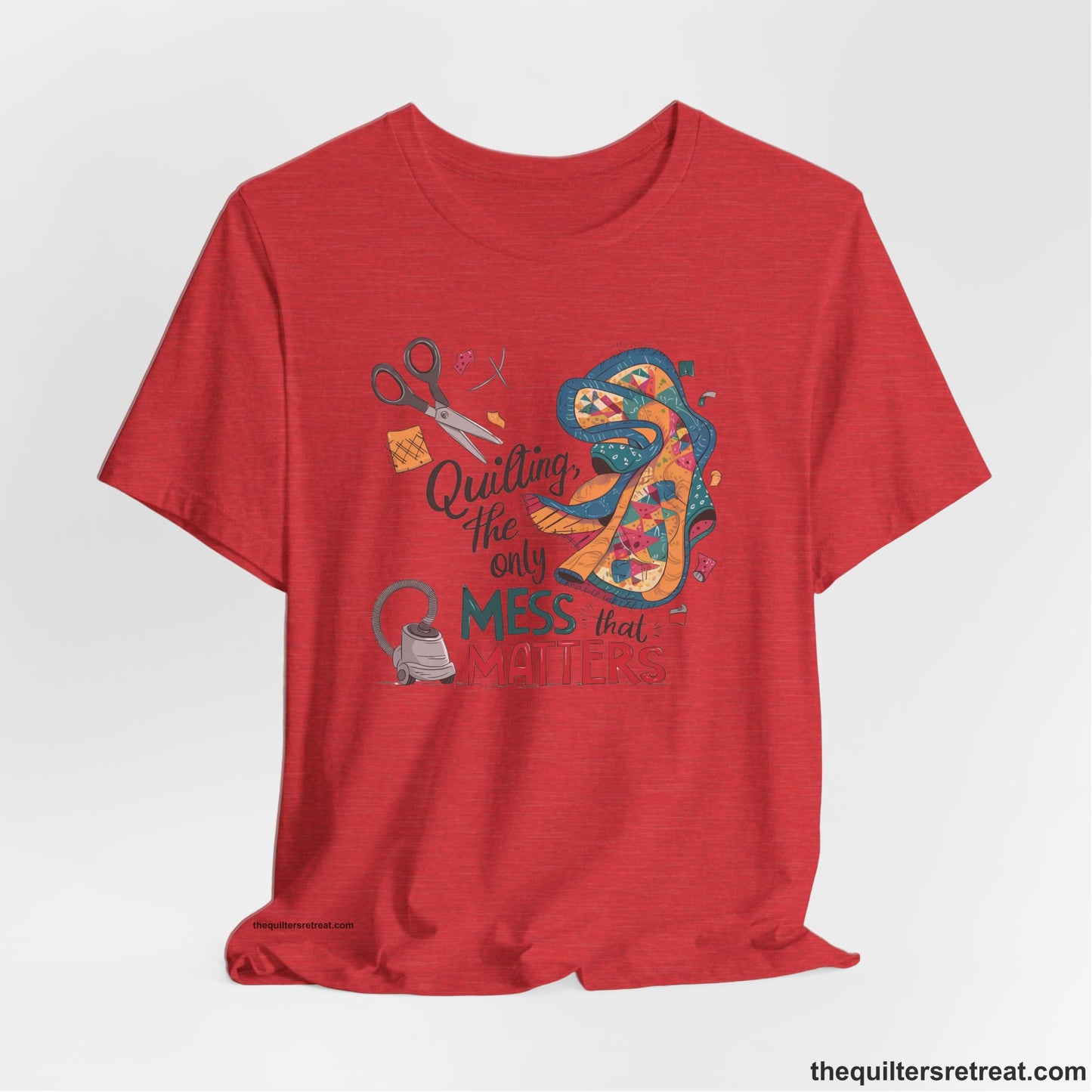 A Heather Red Short Sleeve T-Shirt with a quilting tools and patchwork pieces with bold "Quilting, the only mess that matters" text