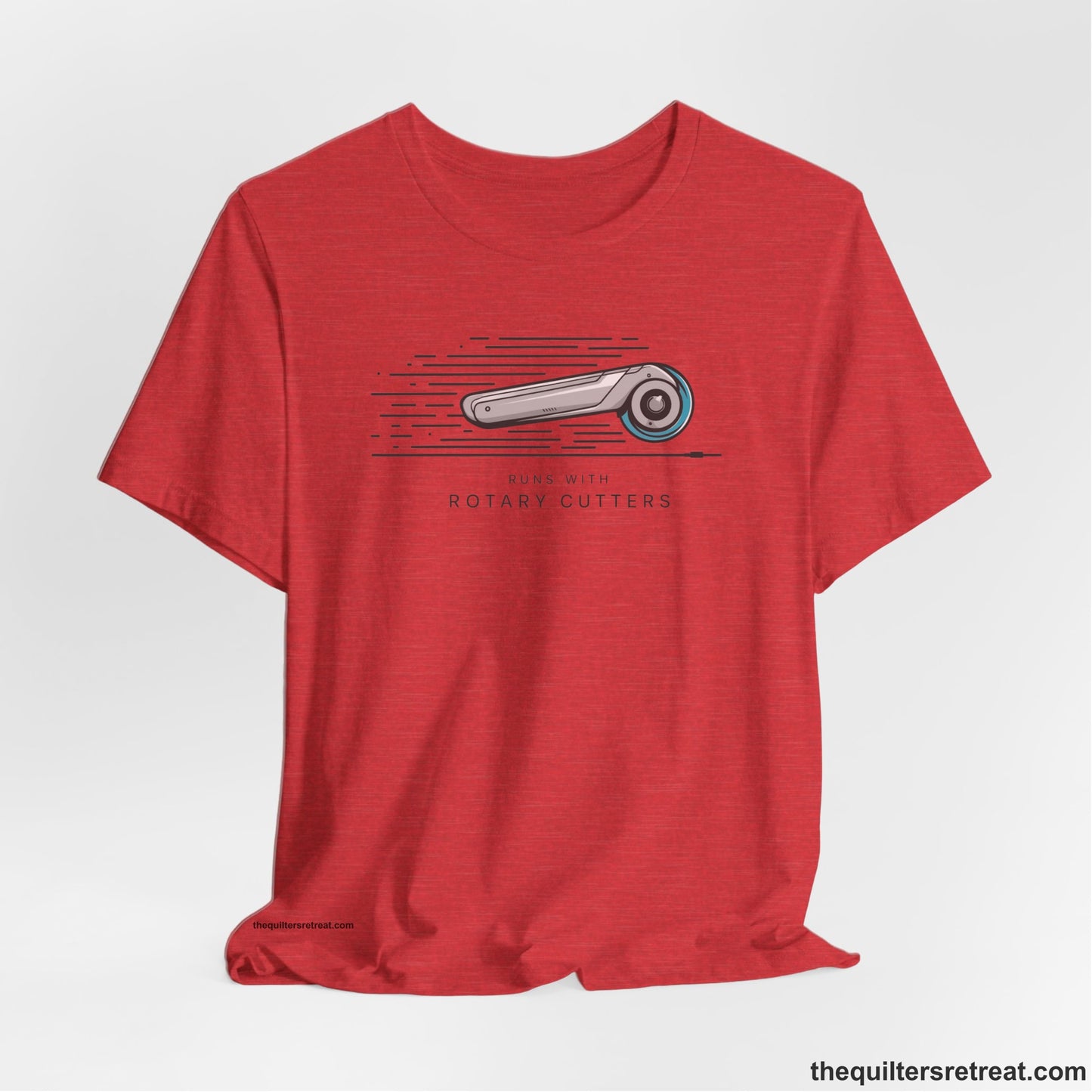 A Heather Red Short Sleeve T-Shirt with a rotary cutter illustration with dynamic lines and bold "Runs with Rotary Cutters" text
