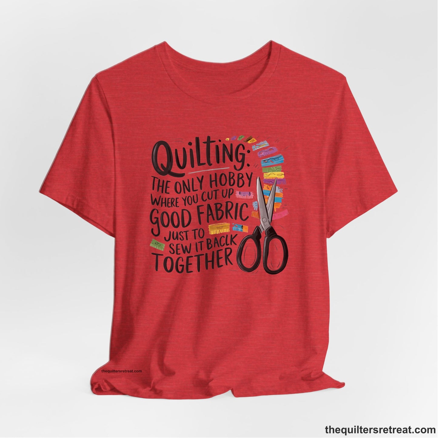 A Heather Red Short Sleeve T-Shirt with a quilting-themed text with colorful fabric pieces and scissors in a whimsical style