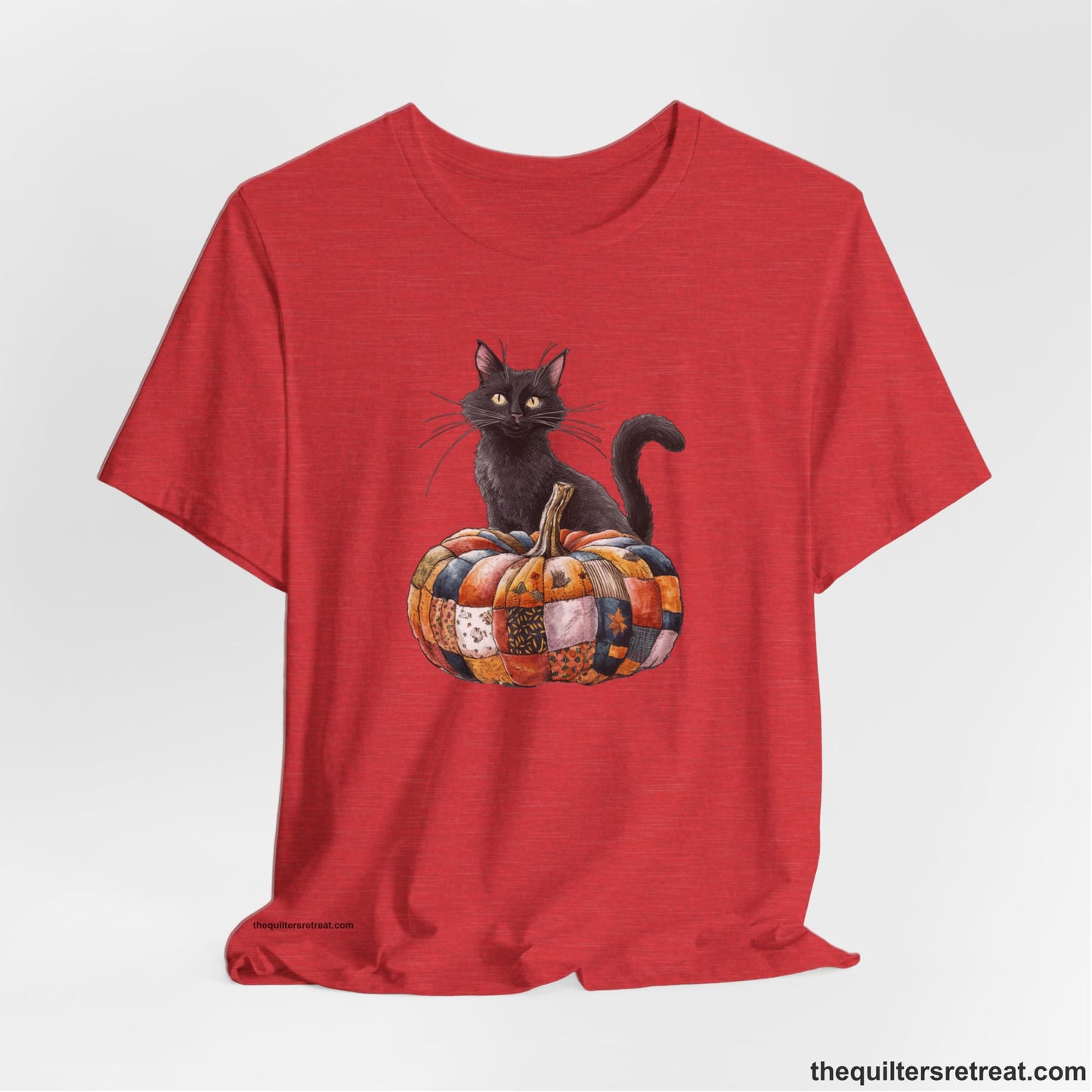 A Heather Red Short Sleeve T-Shirt with a black cat with a quilted patchwork pumpkin in a whimsical autumn style