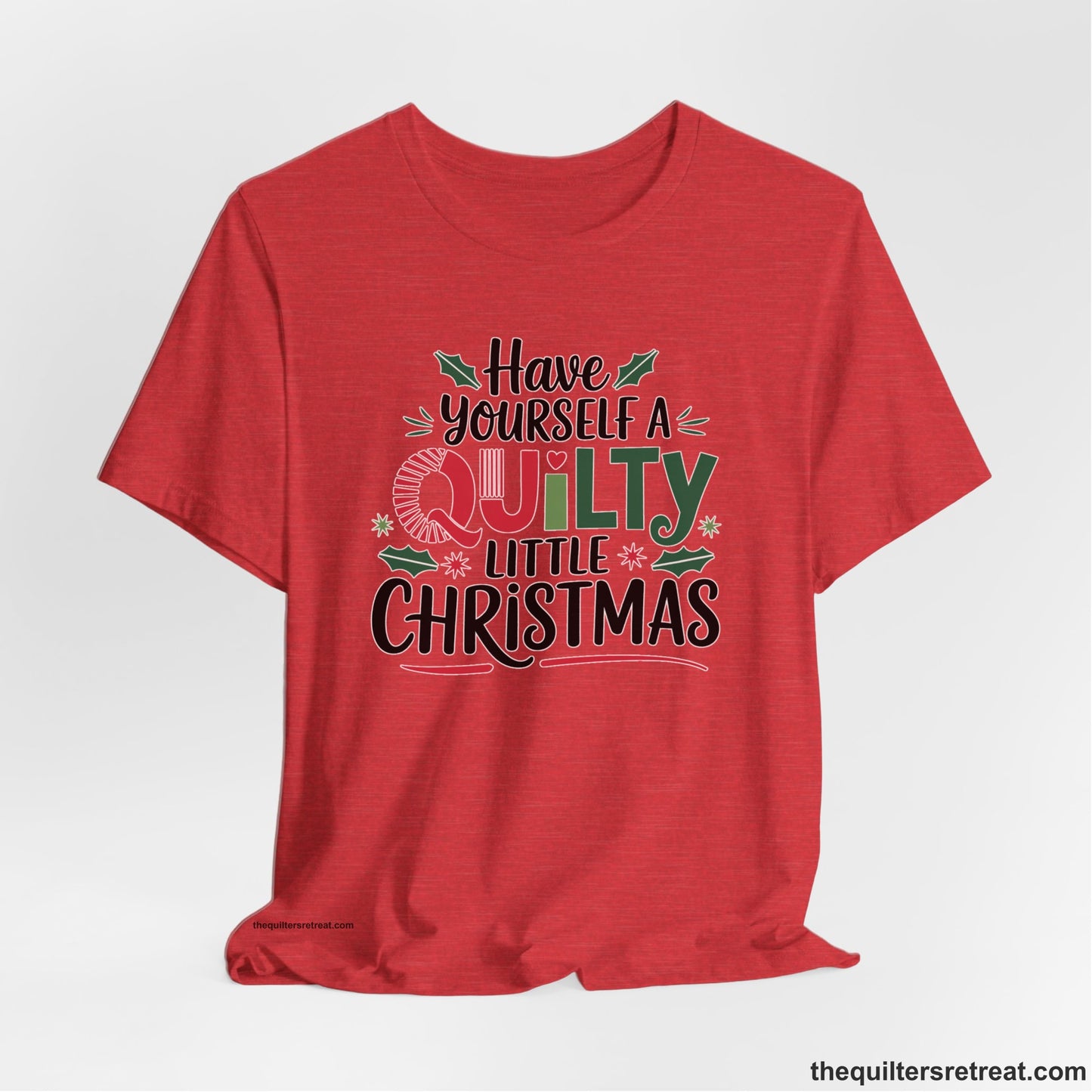 A Heather Red Short Sleeve T-Shirt with a festive "Have Yourself a Quilty Little Christmas" text with holly and quilt patterns