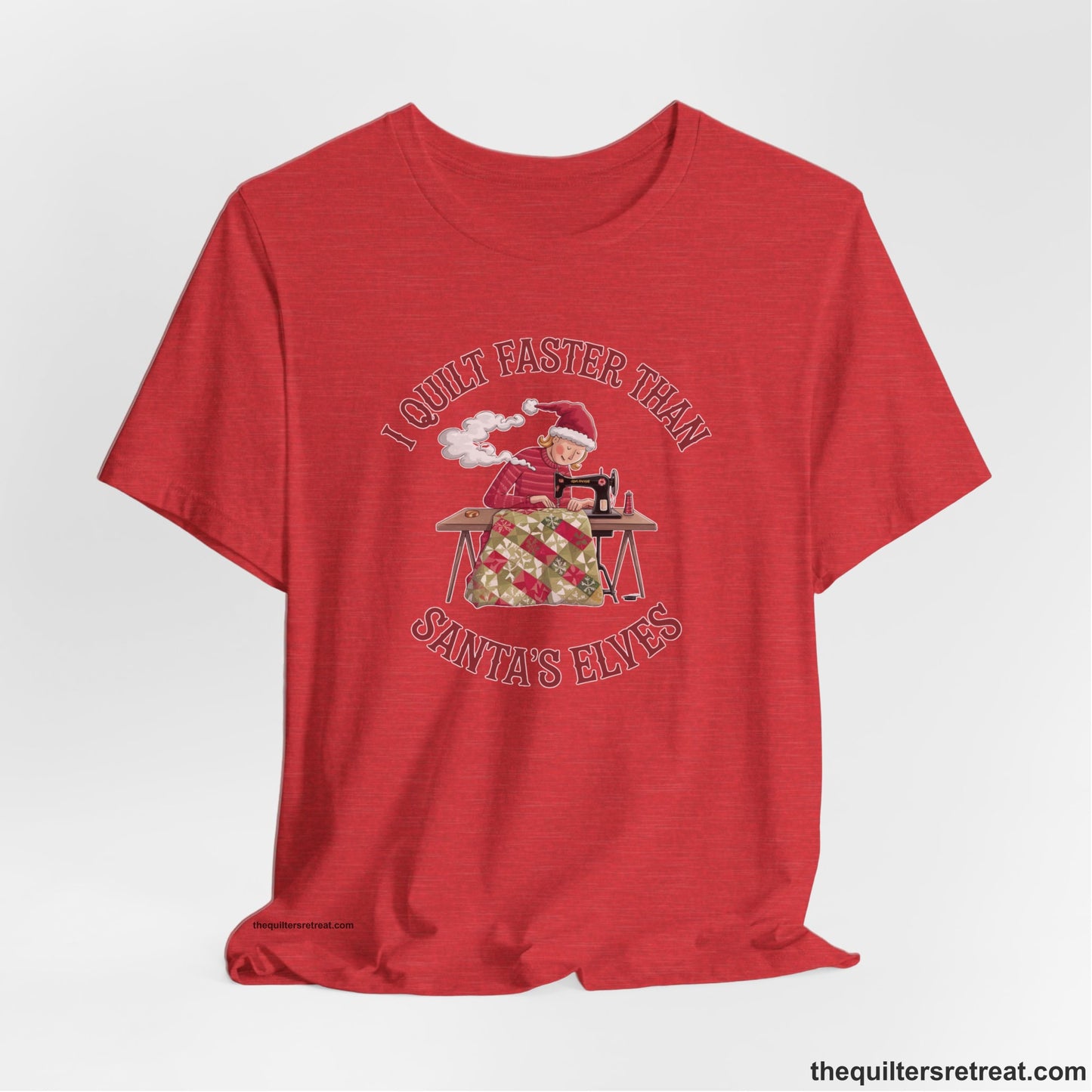 A Heather Red Short Sleeve T-Shirt with a whimsical illustration of a quilting woman with "I Quilt Faster Than Santa's Elves" text