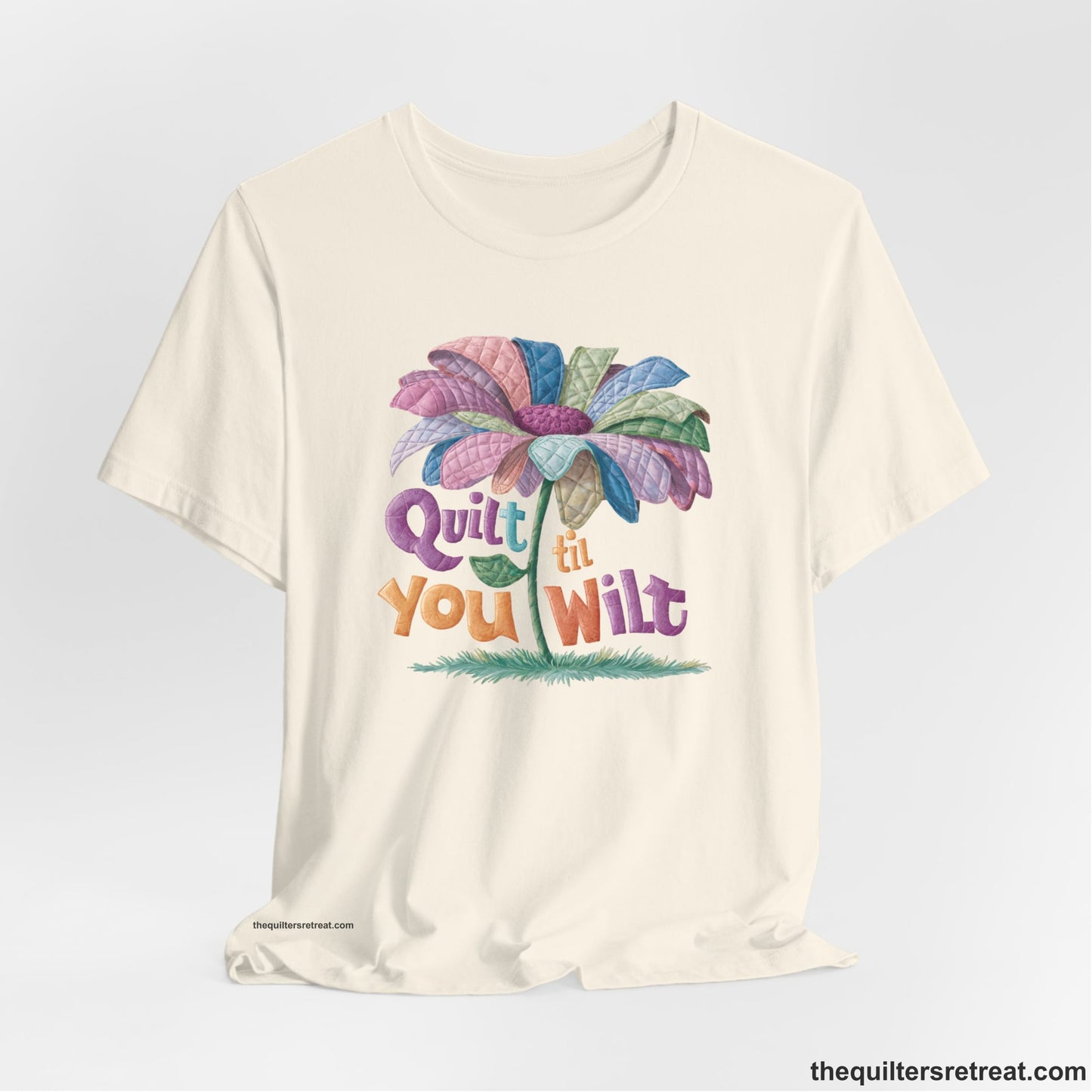 A Natural Short Sleeve T-Shirt with a whimsical quilted flower with bold "Quilt til You Wilt" text