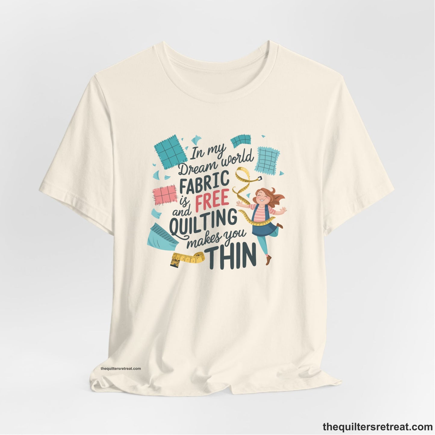 A Natural Short Sleeve T-Shirt with a inspirational quilting text with playful seamstress and colorful fabric scraps in whimsical style