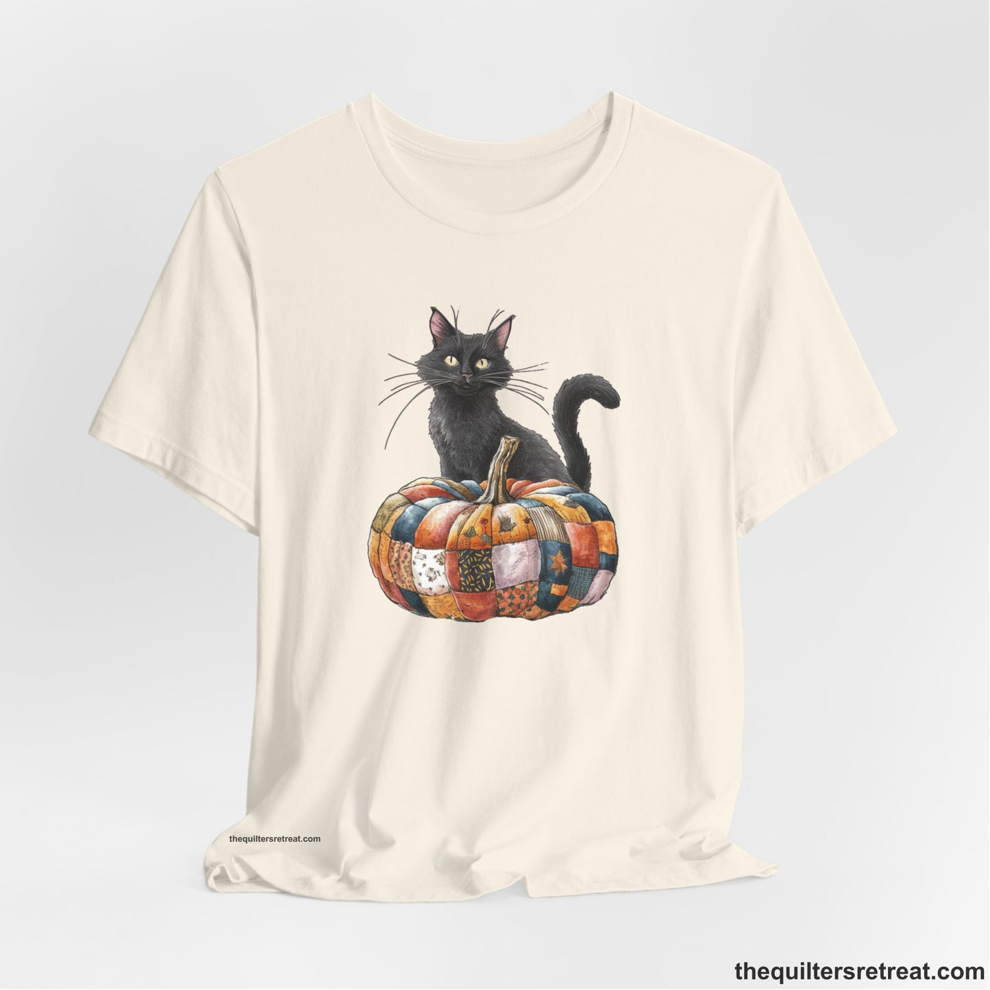 A Natural Short Sleeve T-Shirt with a black cat with a quilted patchwork pumpkin in a whimsical autumn style