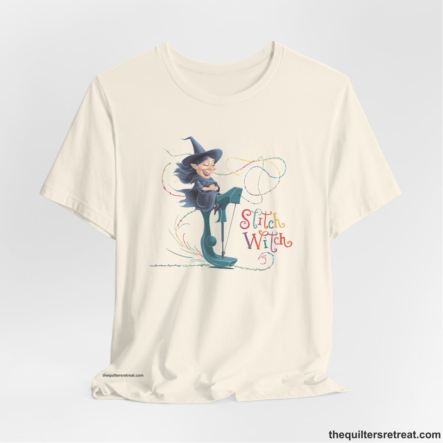 A Natural Short Sleeve T-Shirt with a witch on vintage sewing machine with "Stitch Witch" text in playful, colorful style