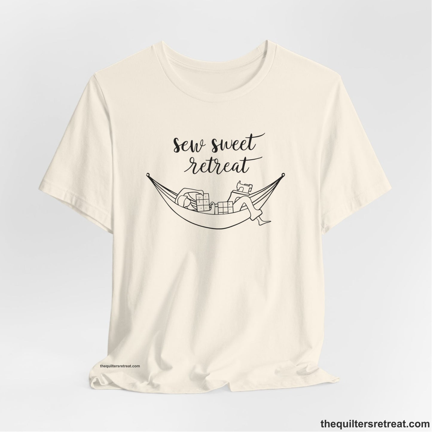 A Natural Short Sleeve T-Shirt with a sewing machine and thread spools with "Sew Sweet Retreat" in whimsical script