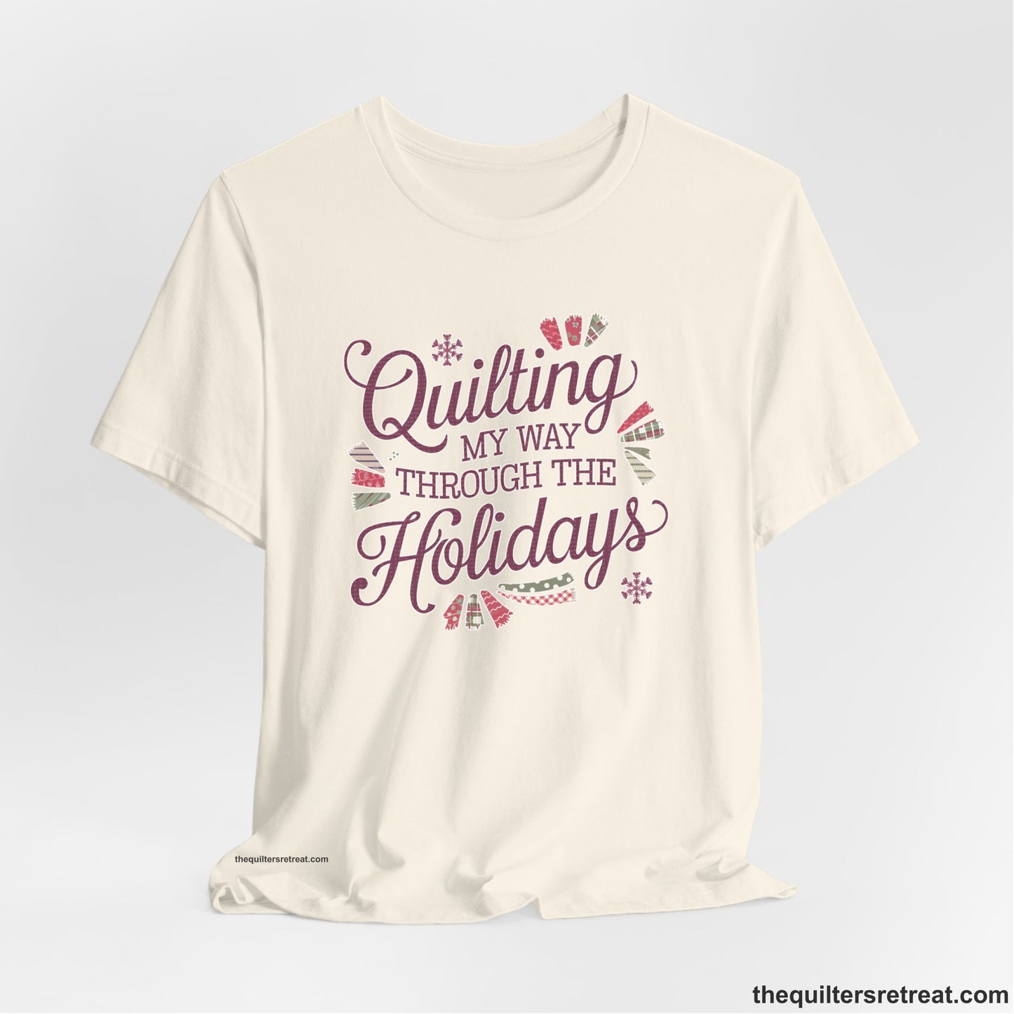 A Natural Short Sleeve T-Shirt with a quilting-themed text in festive colors with decorative quilt patterns