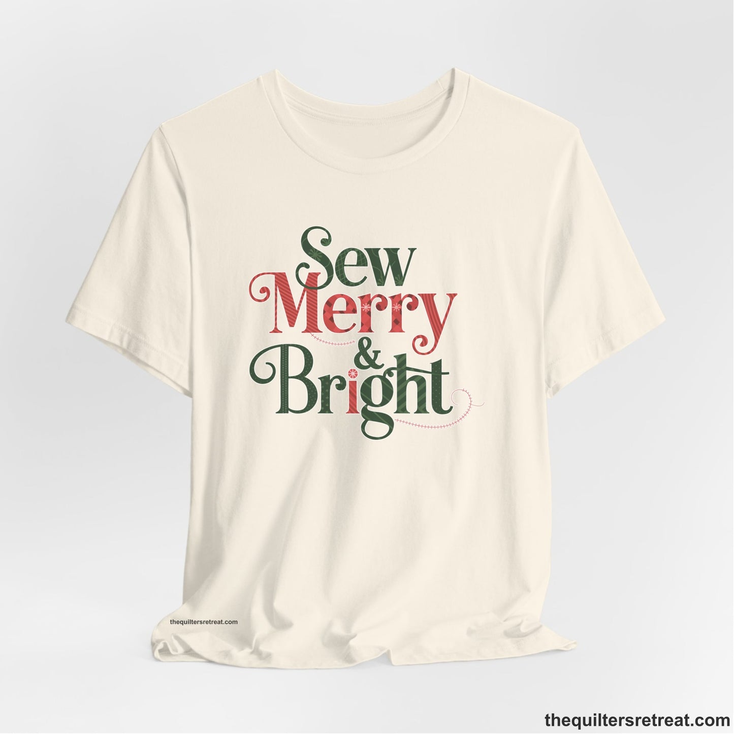 A Natural Short Sleeve T-Shirt with a festive "Sew Merry & Bright" text with decorative holiday patterns