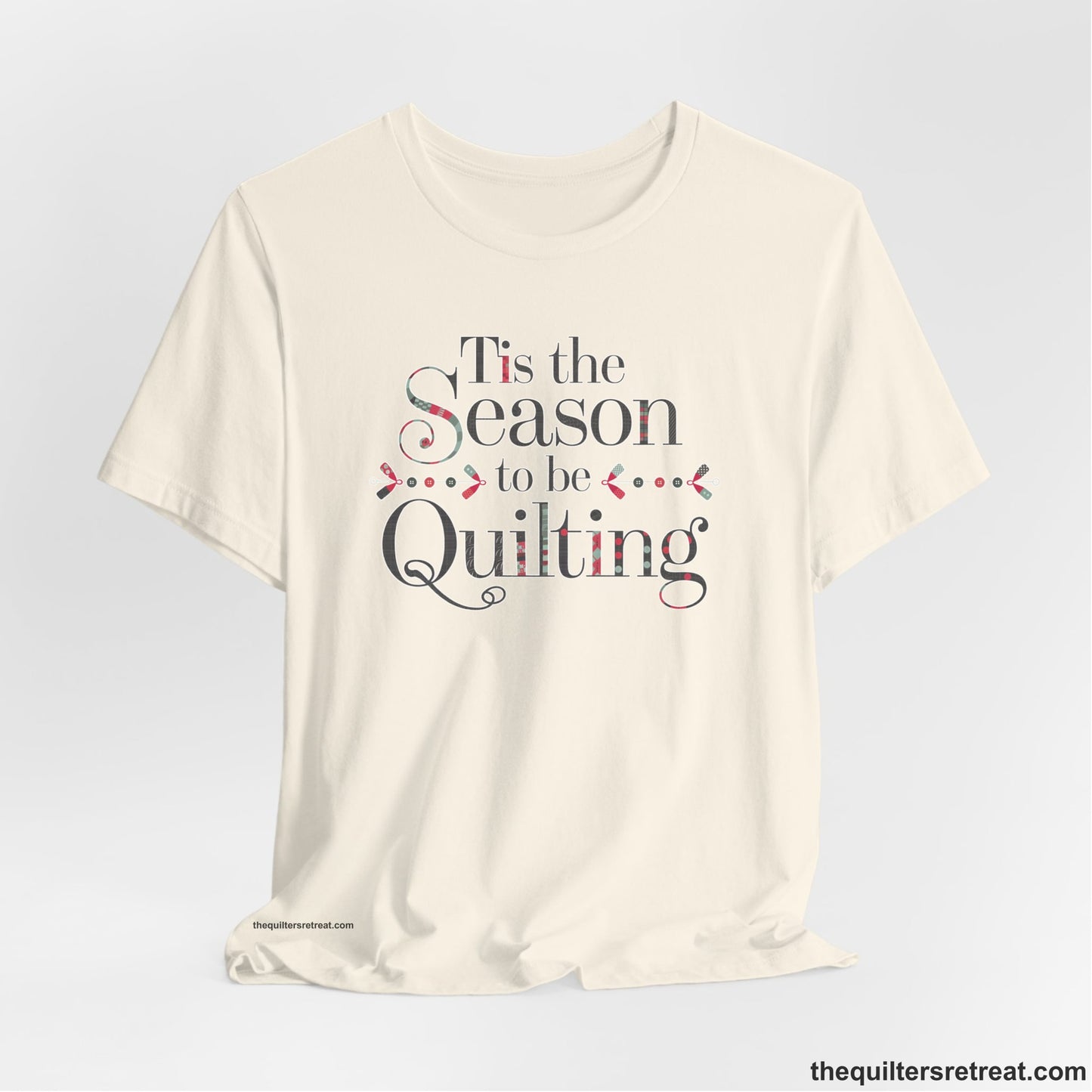 A Natural Short Sleeve T-Shirt with a tis the season to be quilting text with festive patchwork pattern in a cheerful style