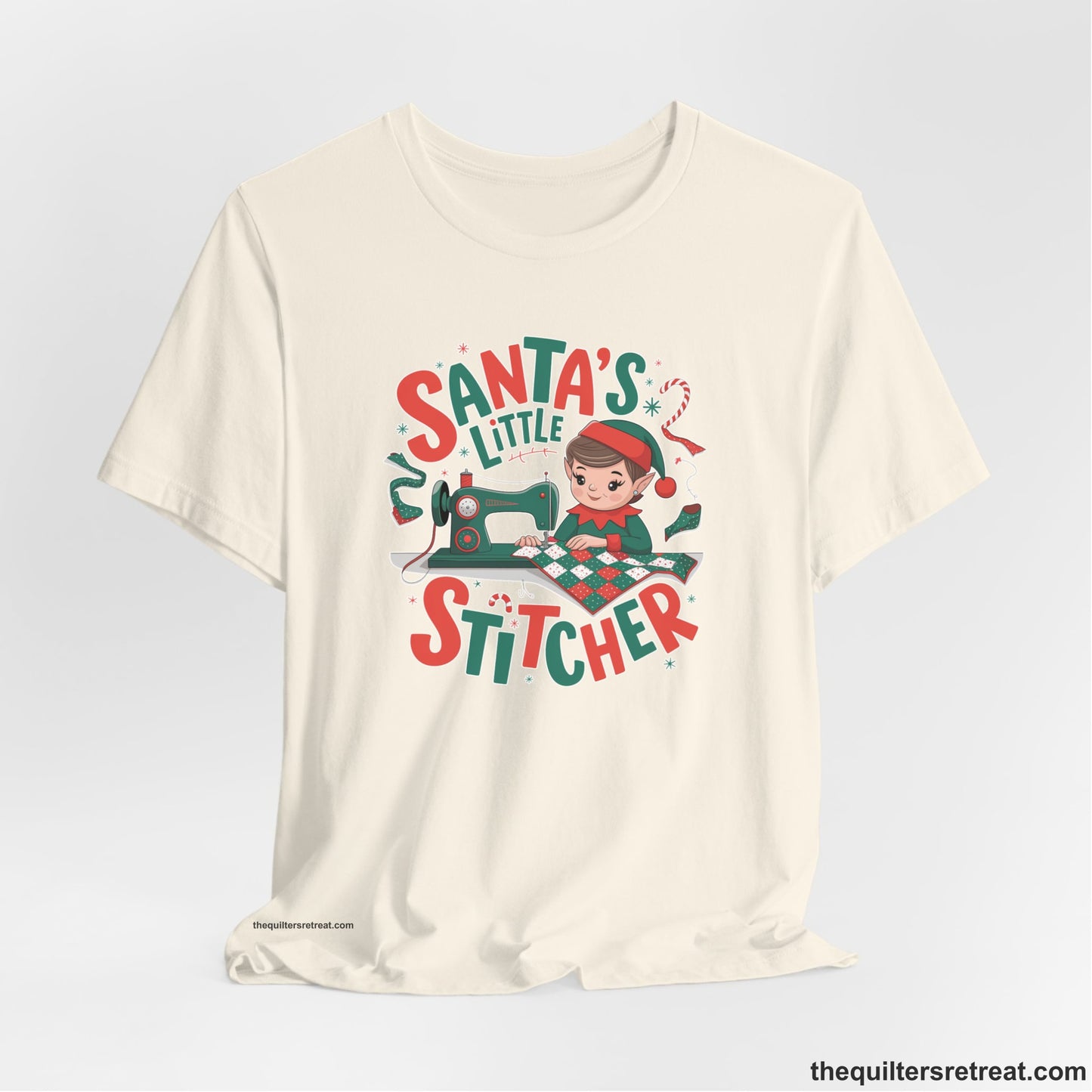 A Natural Short Sleeve T-Shirt with a santa's little stitcher elf sewing quilt with festive colors in playful style