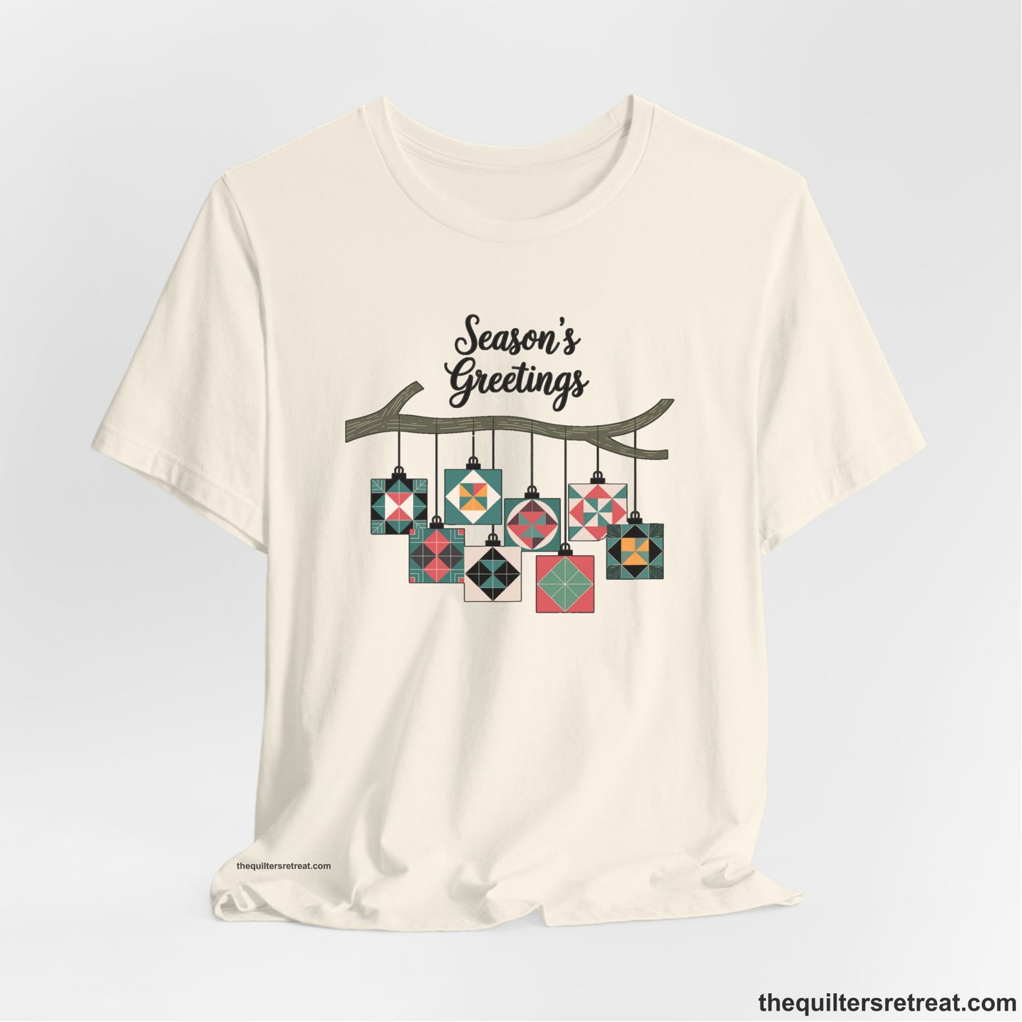 A Natural Short Sleeve T-Shirt with a season's greetings text above colorful quilt block ornaments on tree branch in rustic style