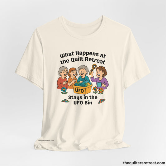 A Natural Short Sleeve T-Shirt with a four smiling women with unfinished fabric objects and playful "UFO" text in a cartoon style