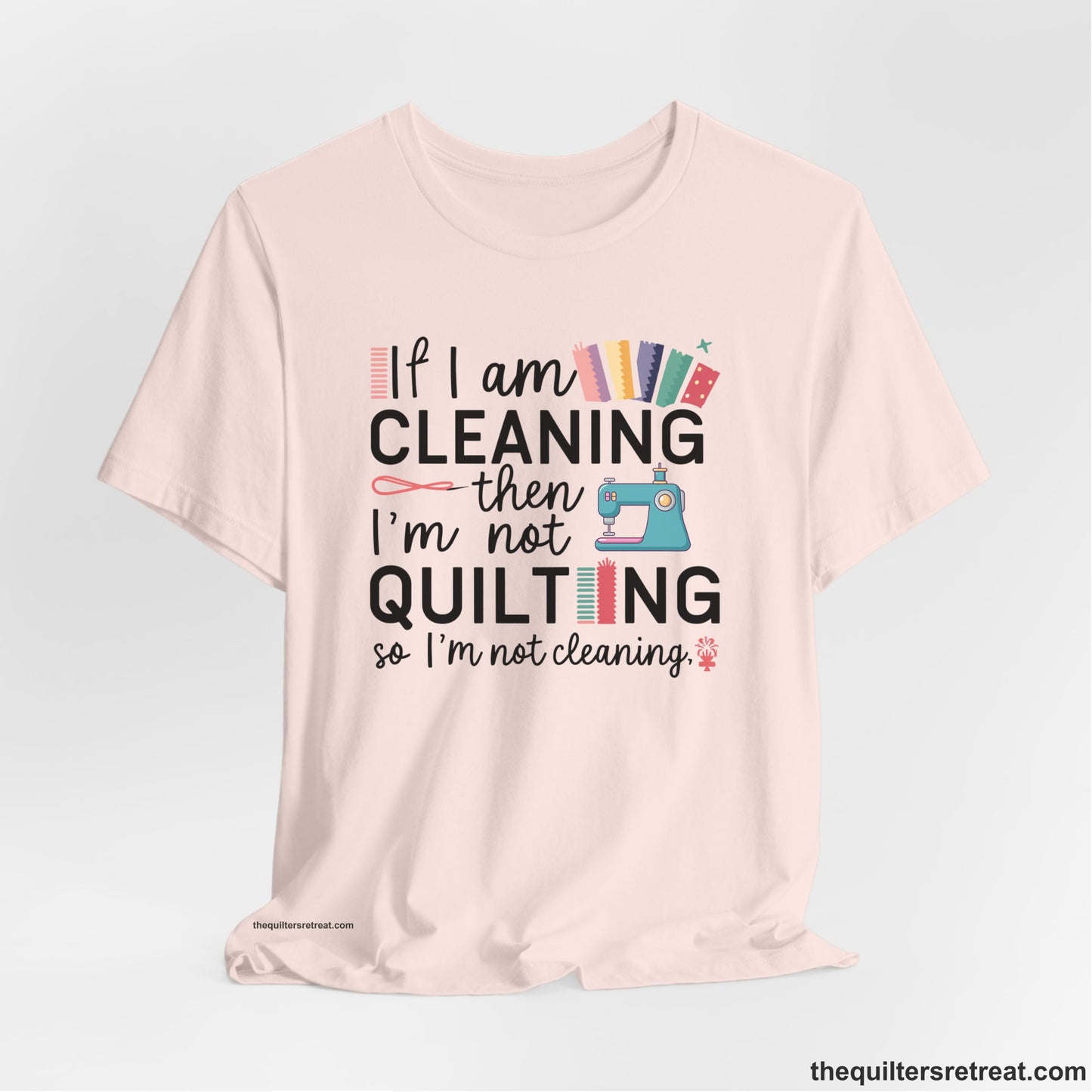 A Soft Pink Short Sleeve T-Shirt with a If I am cleaning then I'm not quilting text with sewing machine and fabric graphics