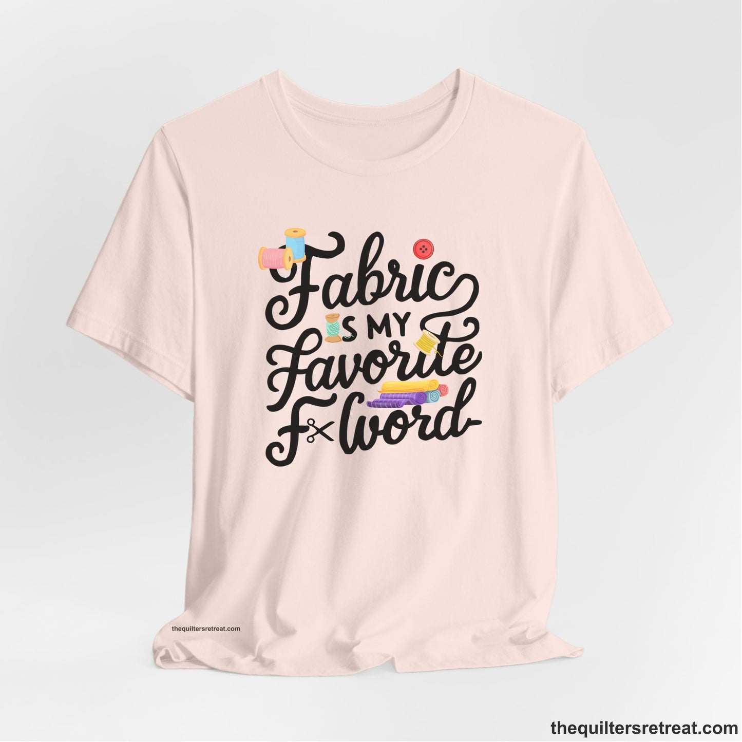 A Soft Pink Short Sleeve T-Shirt with a fabric is my favorite f word text with colorful spools and buttons in a playful style
