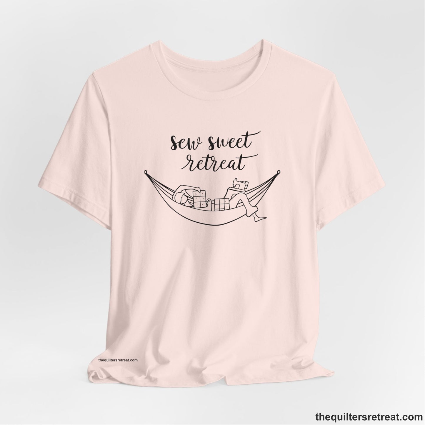 A Soft Pink Short Sleeve T-Shirt with a sewing machine and thread spools with "Sew Sweet Retreat" in whimsical script