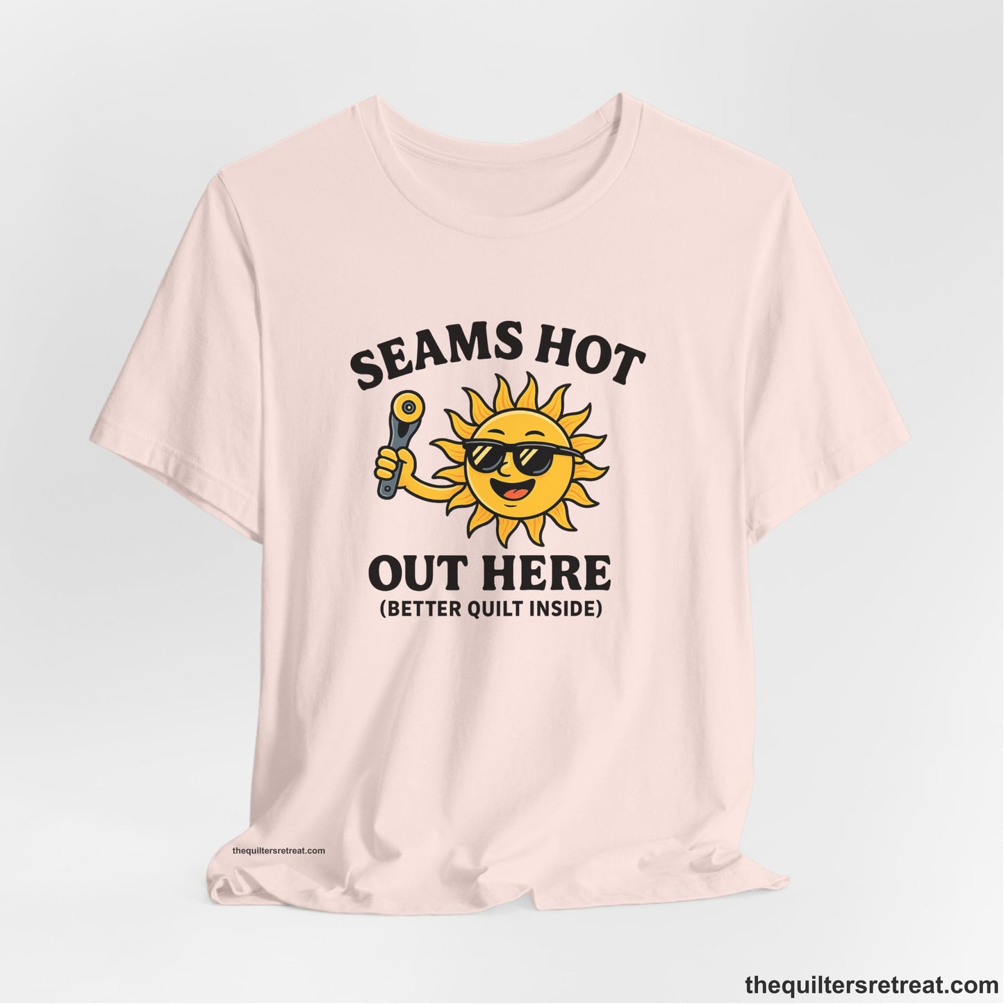 A Soft Pink Short Sleeve T-Shirt with a smiling sun with sunglasses holding a pizza cutter in a playful cartoon style