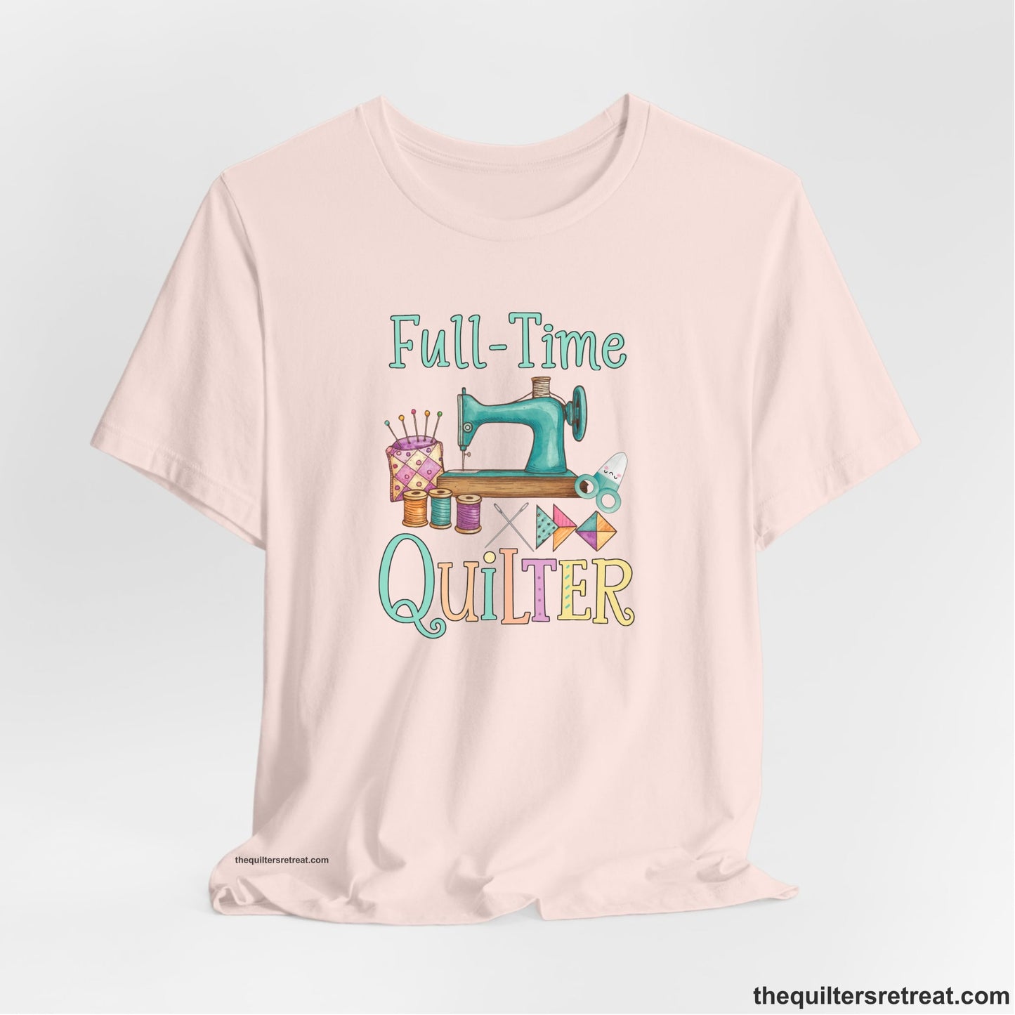 A Soft Pink Short Sleeve T-Shirt with a vintage sewing machine with colorful threads and "Full-Time Quilter" text in playful style