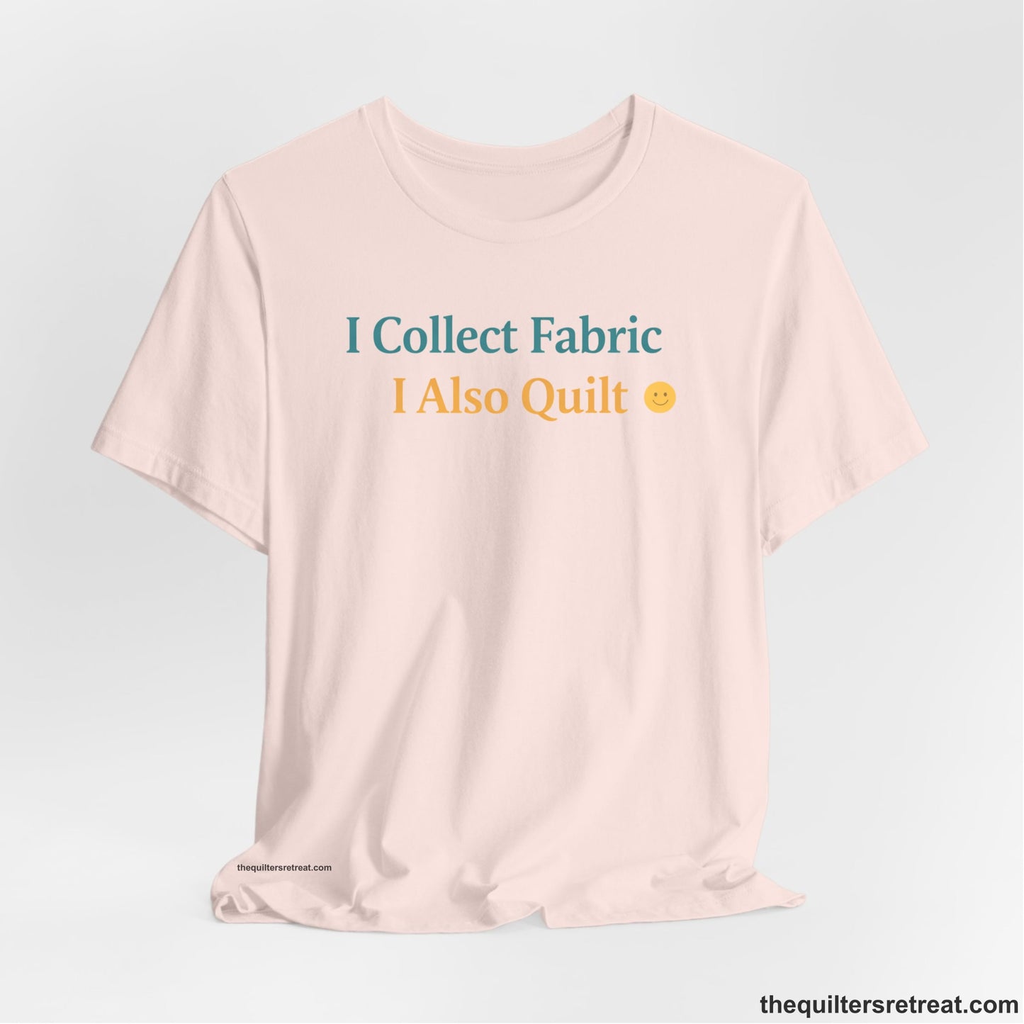 A Soft Pink Short Sleeve T-Shirt with a Colorful text saying "I Collect Fabric I Also Quilt" with a playful, cheerful vibe.