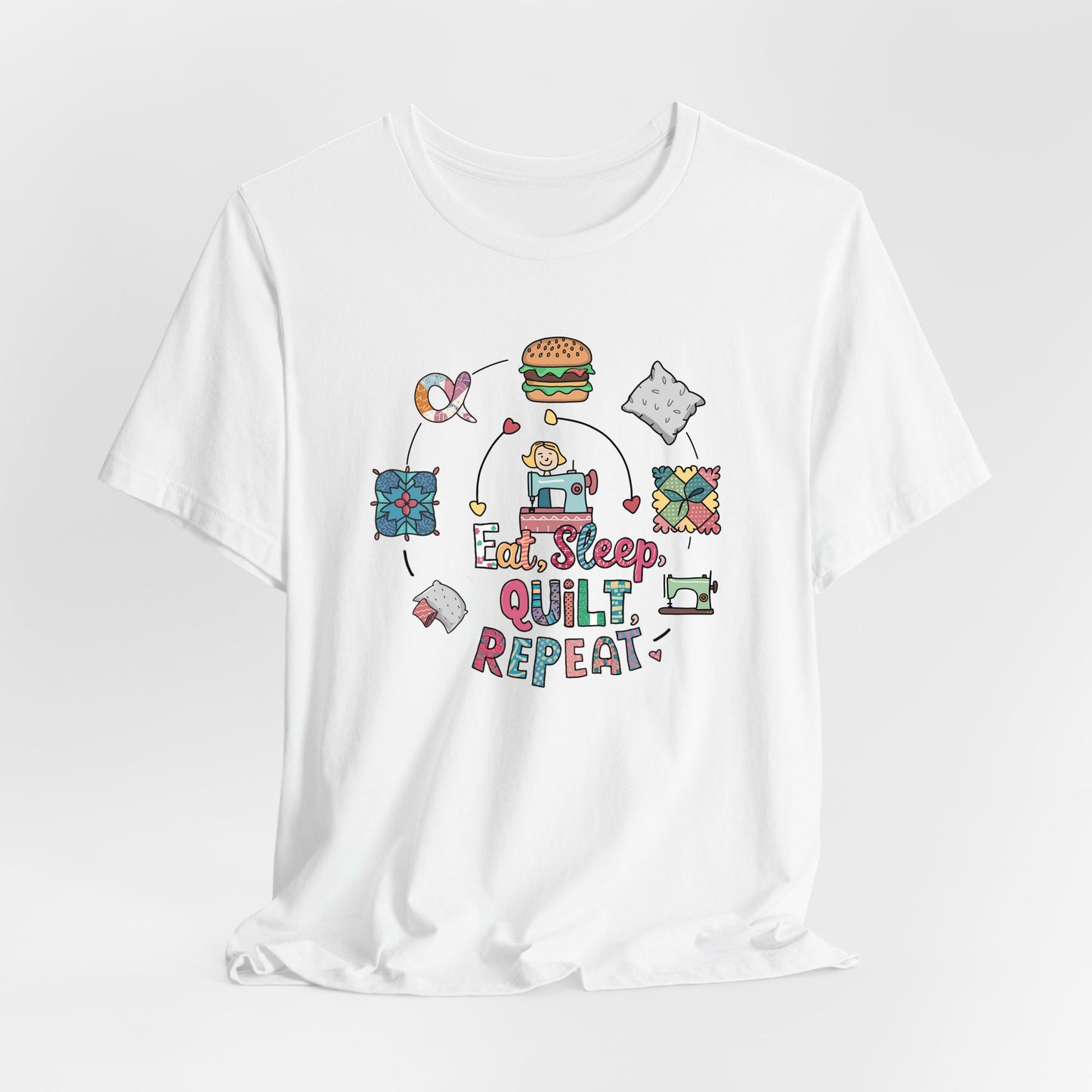 A White Short Sleeve T-Shirt with a cute quilting elements with "Eat, Sleep, Quilt, Repeat" text in playful style