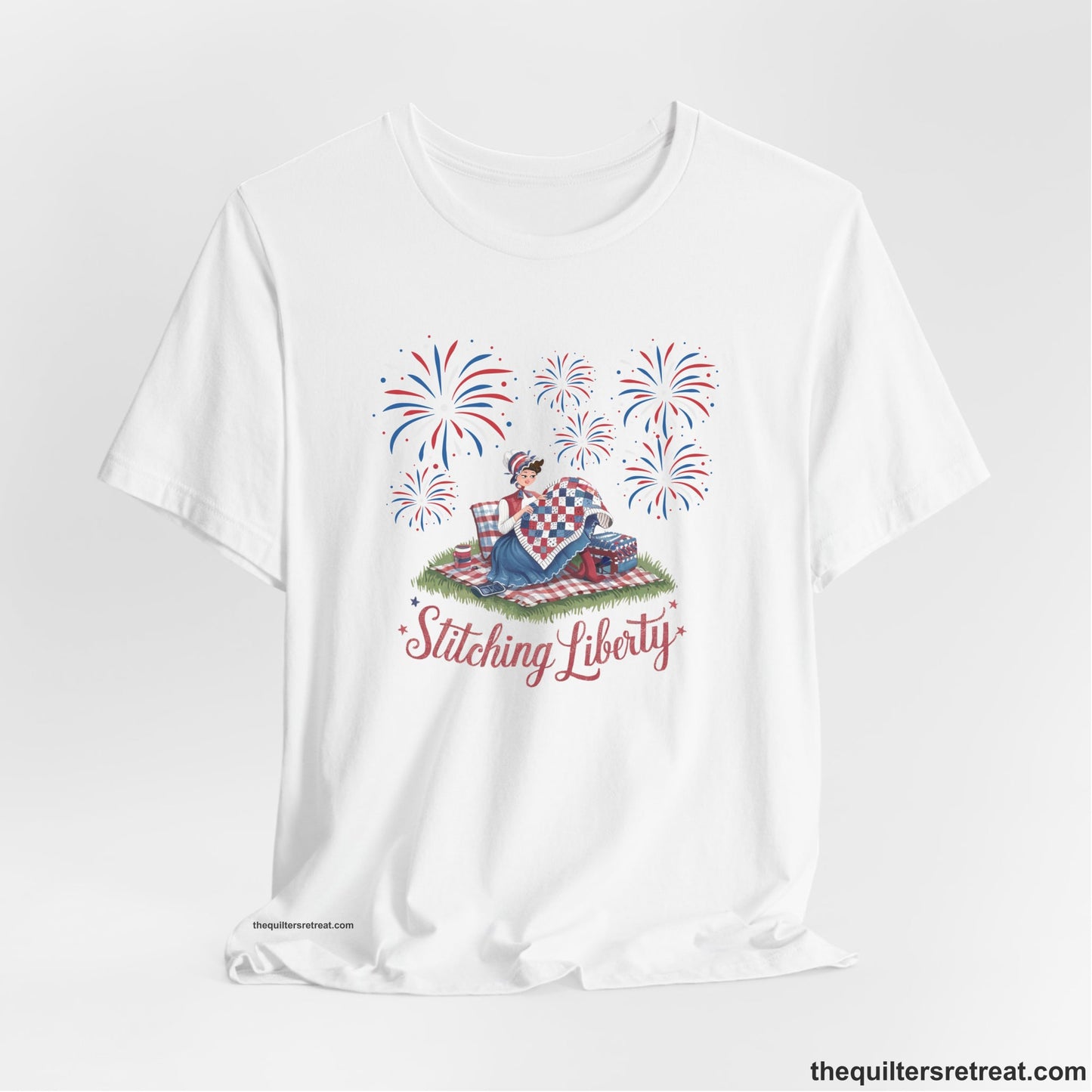 A White Short Sleeve T-Shirt with a vintage illustration of woman quilting with fireworks and "Stitching Liberty" text in patriotic style