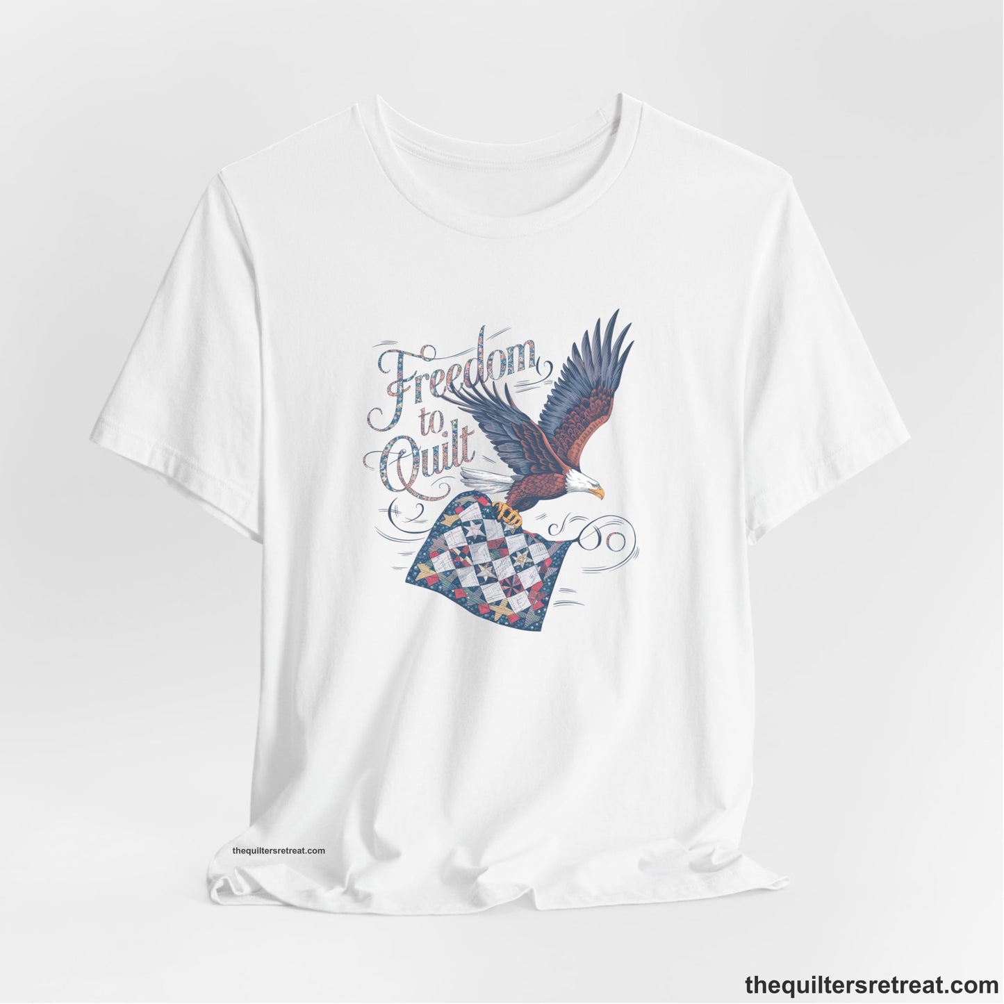 A White Short Sleeve T-Shirt with a freedom to quilt text with an eagle carrying a colorful patchwork quilt in vintage style