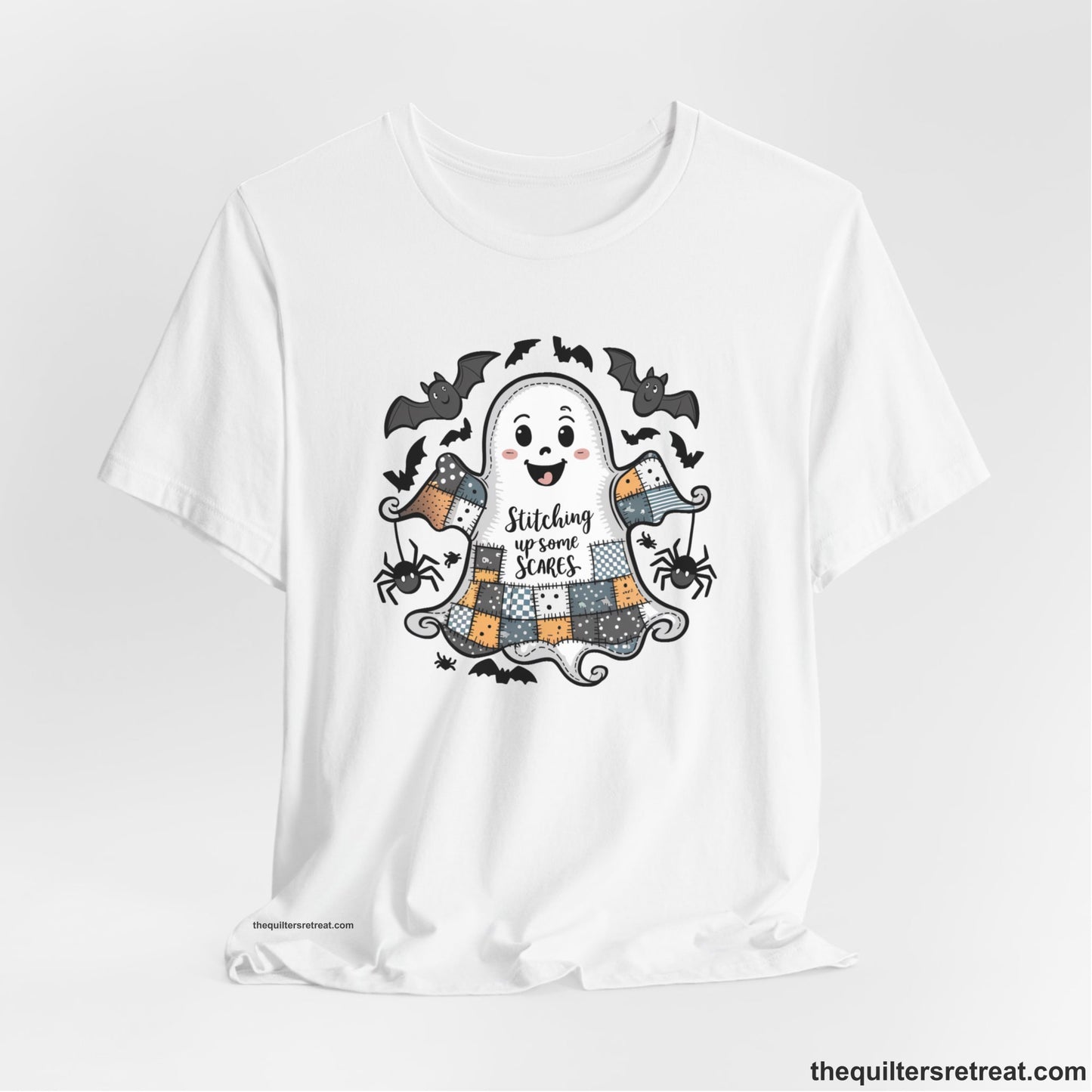 A White Short Sleeve T-Shirt with a cute patchwork ghost with "Stitching up some Scares" text and playful bats in a whimsical style