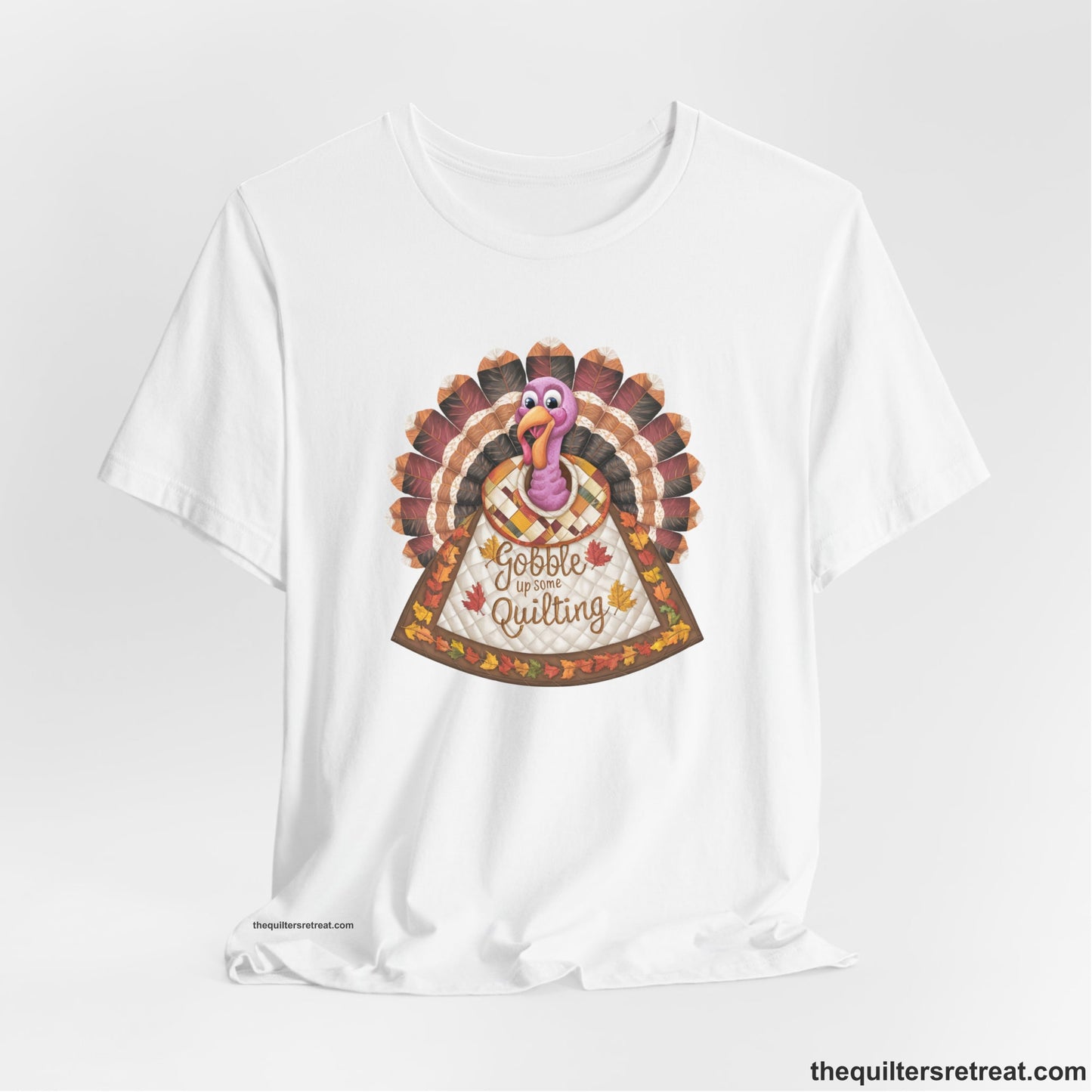 A White Short Sleeve T-Shirt with a colorful turkey with quilted feathers and "Gobble Up Some Quilting" text in a playful style