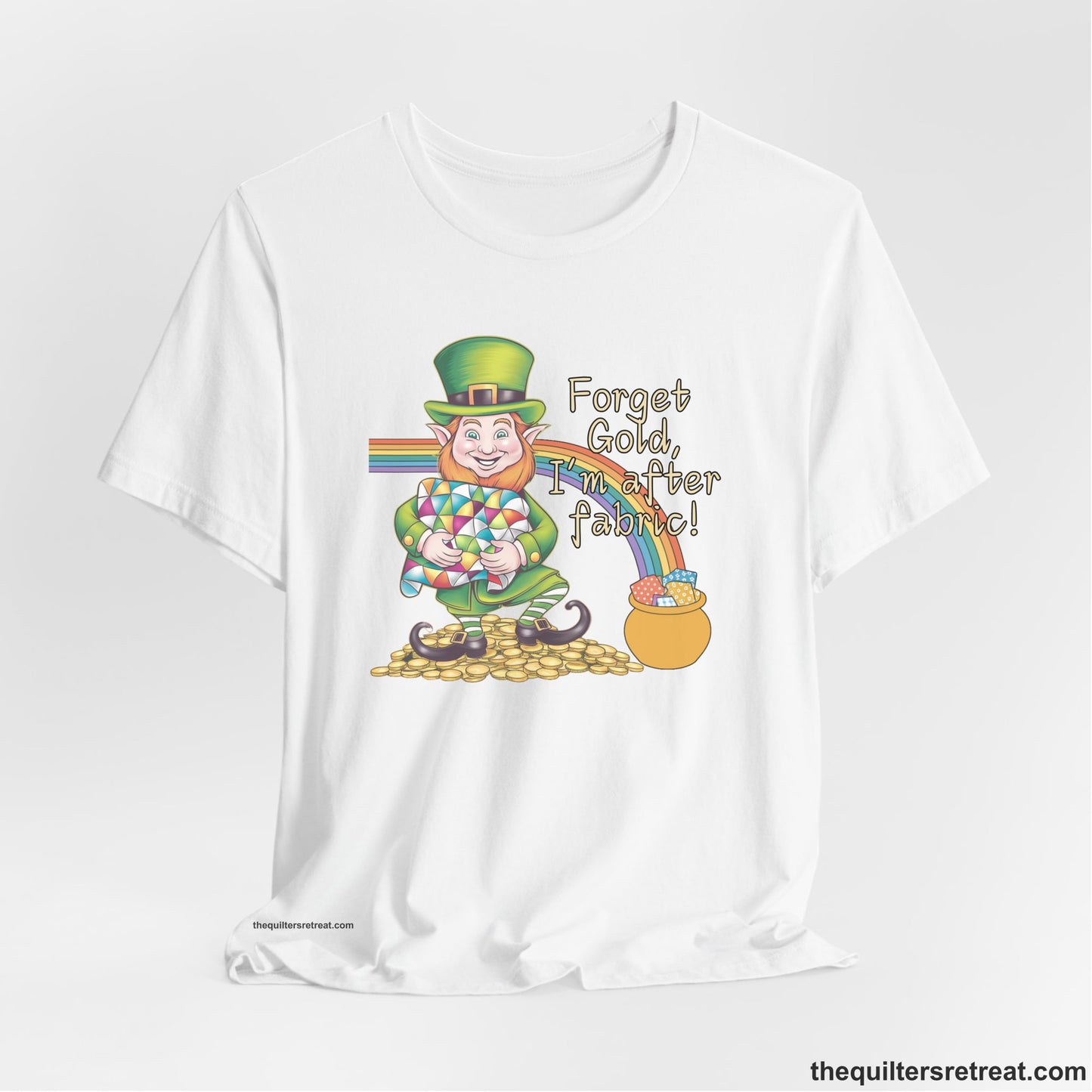 A White Short Sleeve T-Shirt with a leprechaun with colorful quilt and rainbow, whimsical "Forget Gold, I'm after fabric!" text