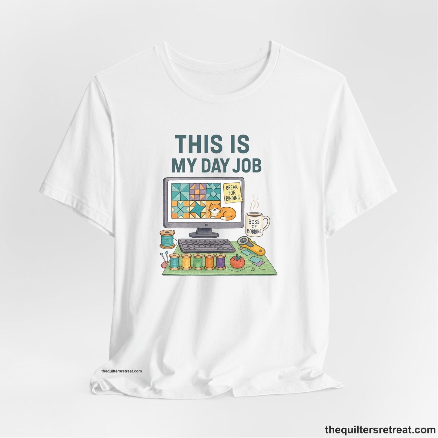 A White Short Sleeve T-Shirt with a computer quilt design, cat illustration, "THIS IS MY DAY JOB" text with sewing tools, playful style
