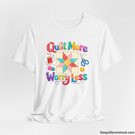 A White Short Sleeve T-Shirt with a Colorful patchwork star and sewing tools, cheerful "Quilt More Worry Less" text.